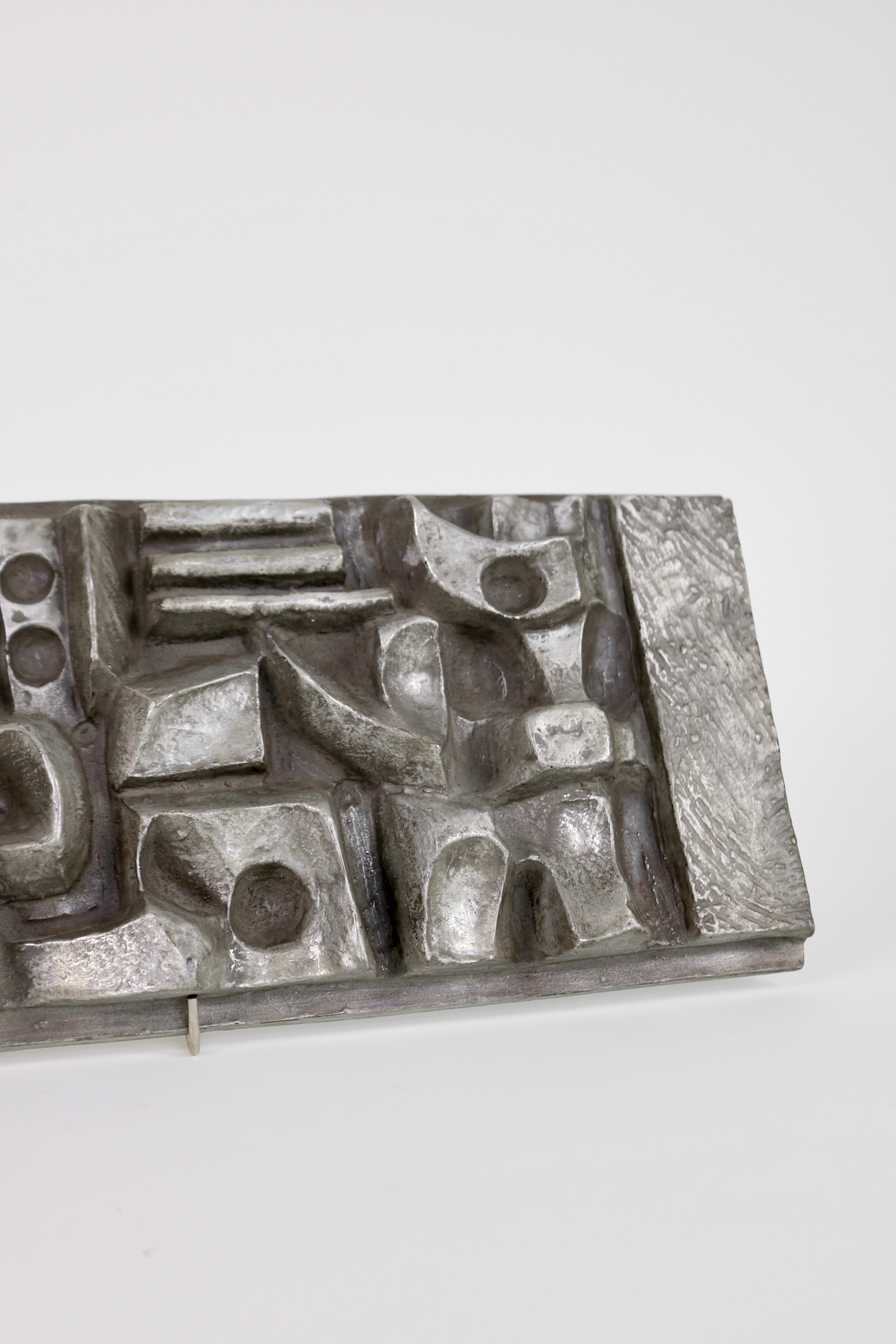 An abstract relief cast by Alfred Russ in 1974. Russ was a German artist exhibiting with the Bayreuth artist circle in the 50s.

This wall piece is a lightweight cast and has hooks for hanging.