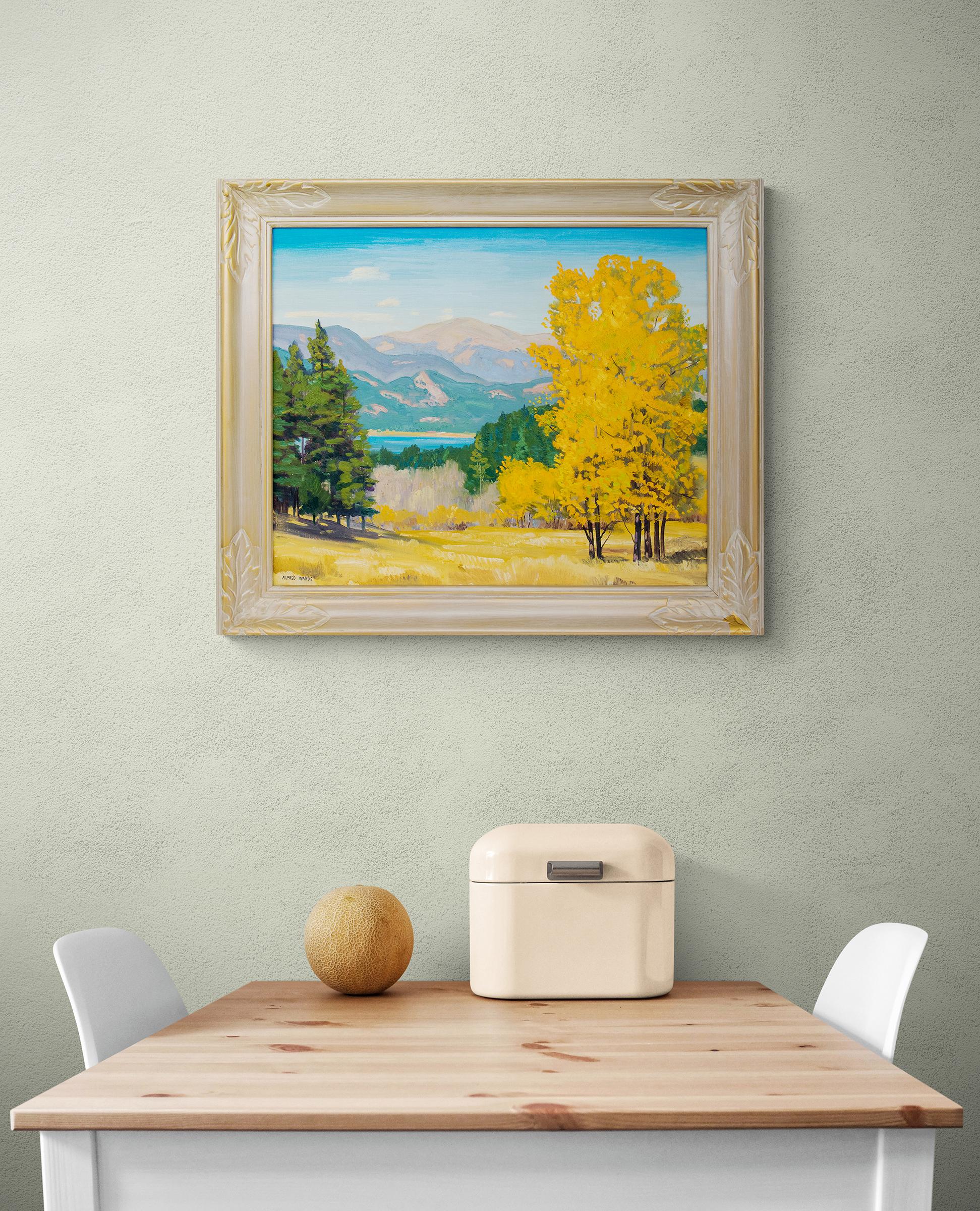Vintage Colorado landscape painting in Autumn with green pine trees and aspen trees with golden leaves, lake and mountains with blue sky. Oil on canvas, signed lower left by the artist, Alfred Wands (1904-1998). Presented in a vintage frame, outer