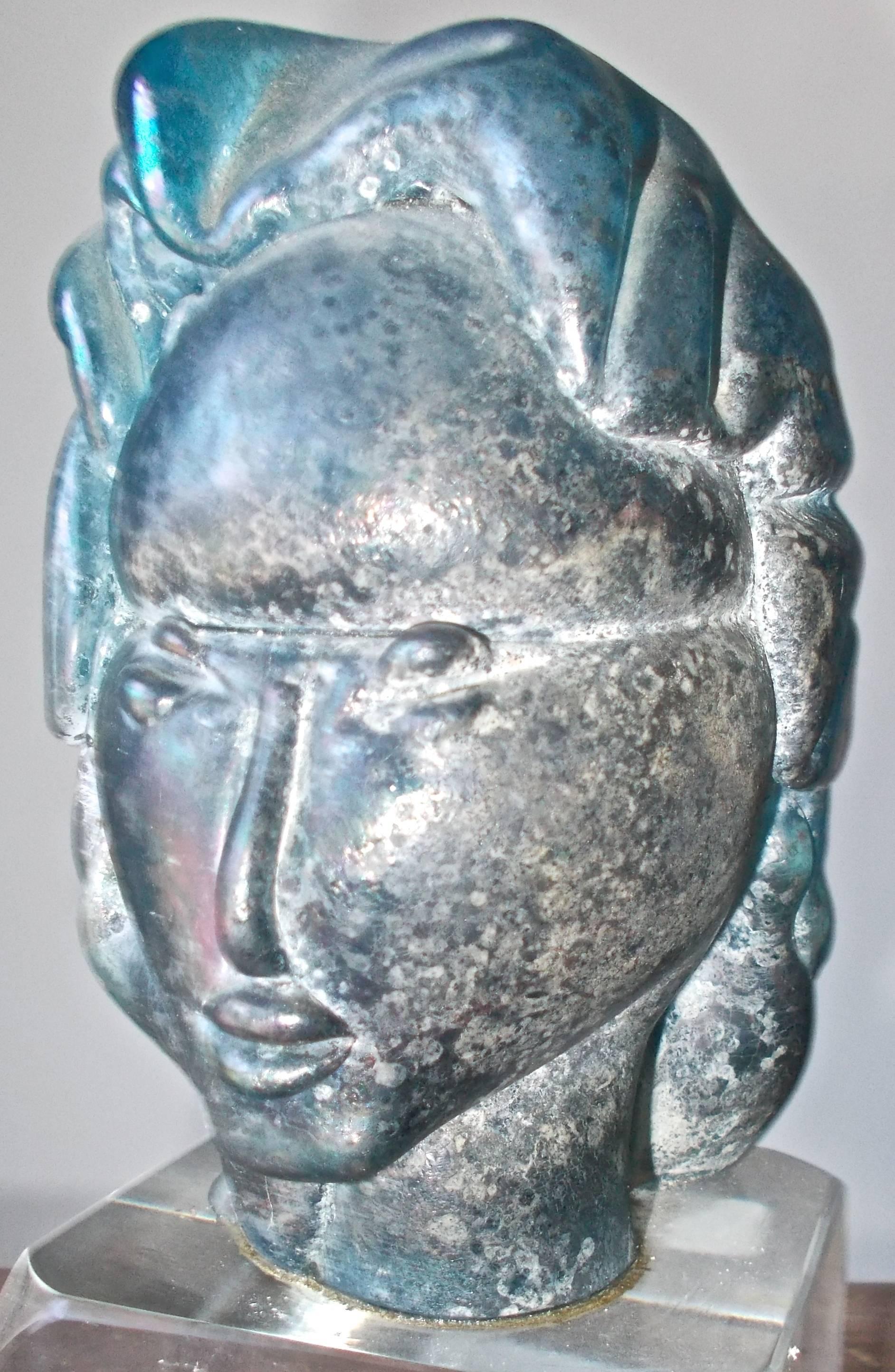 A unique piece sculpted of Iridized blue glass (measurements are of the head itself) sits on a clear 3 1/8