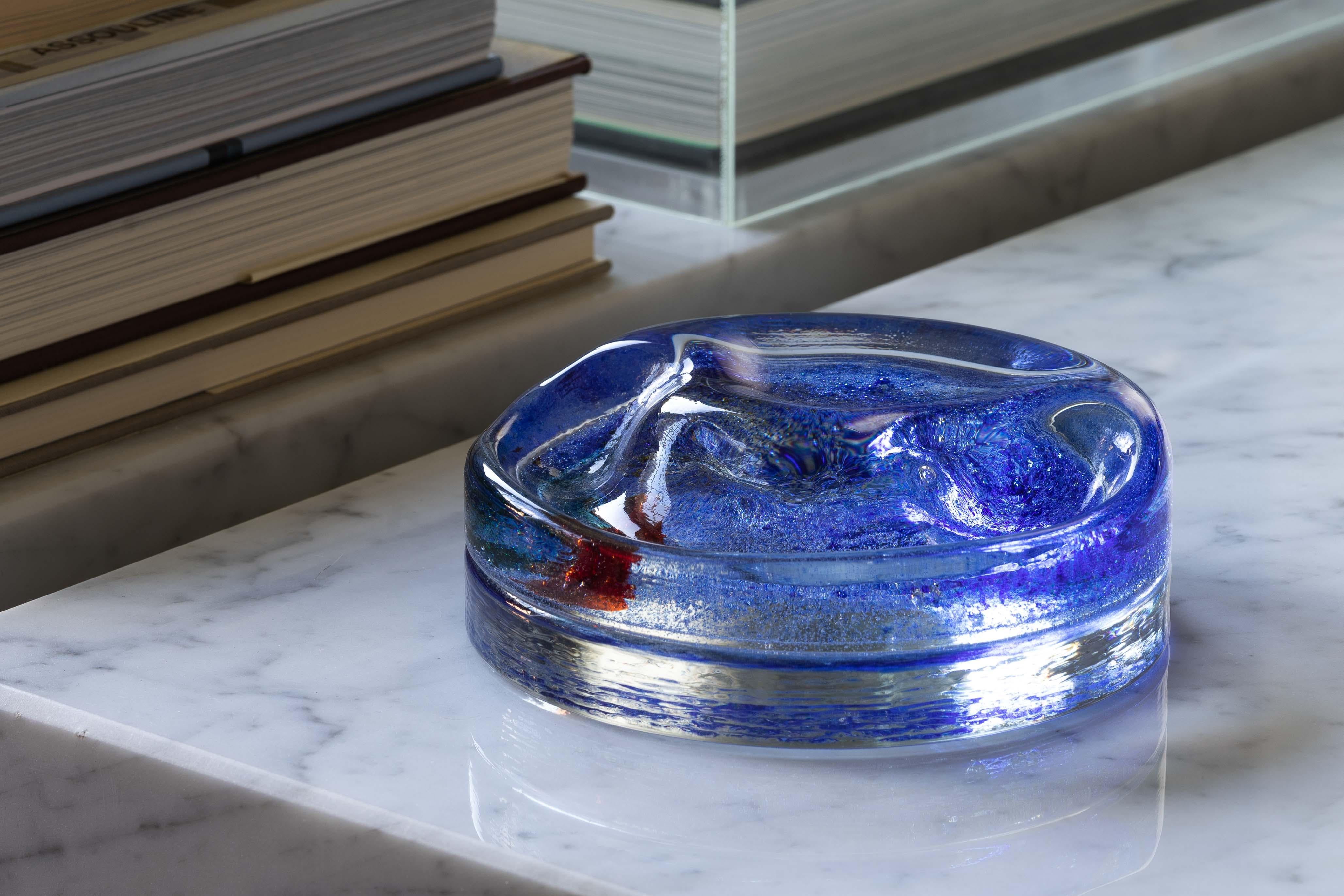 A two-piece cast and blown catchall by Alfredo Barbini for Barbini Murano from the early 1970s. The circular vide-poche has a lower clear textured base, and smooth organic formed upper with a half moon recess. Between the two pieces polychrome oxide