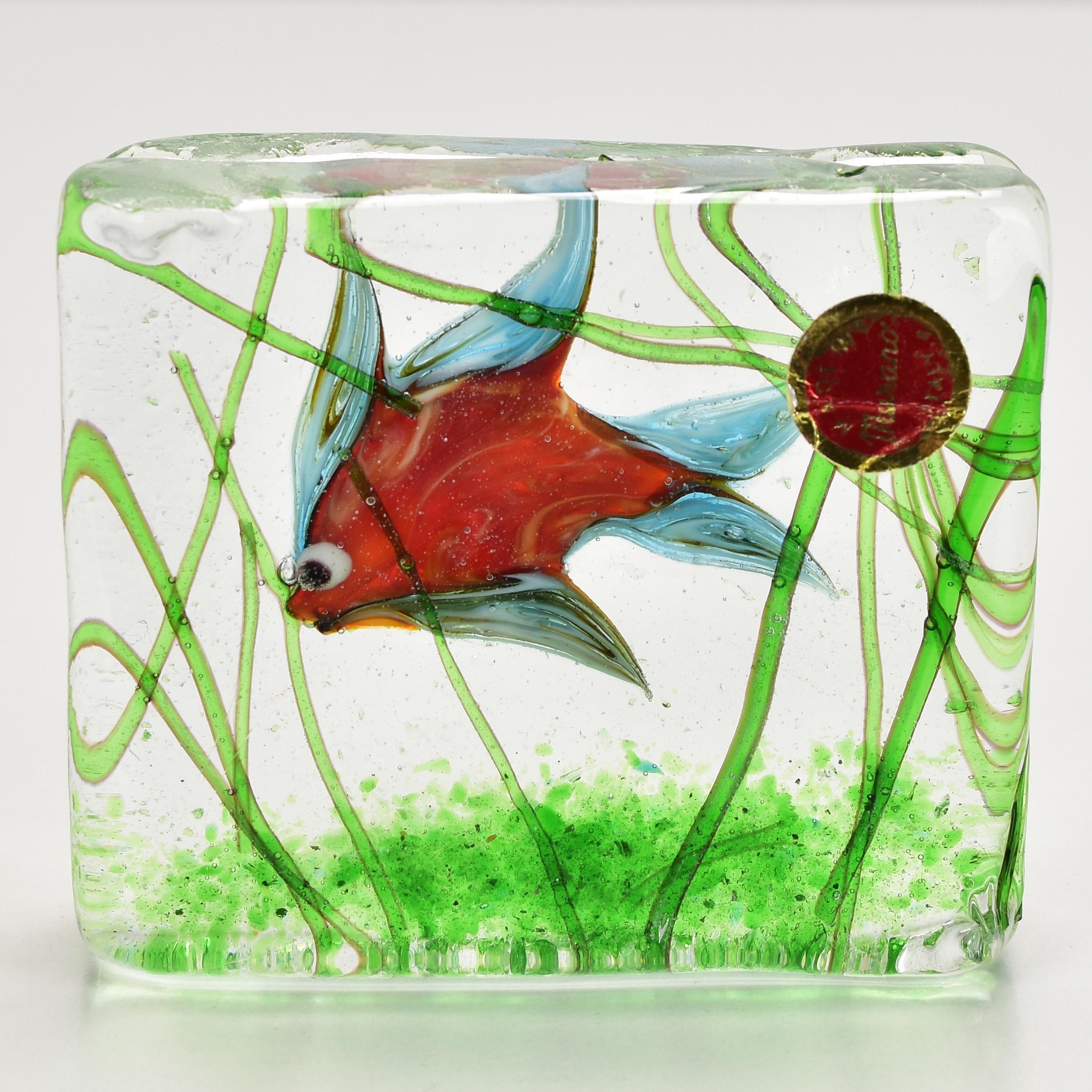 Ravissant presse-papier en forme de bloc aquarium de Murano. Un poisson tropical coloré à l'intérieur d'un bloc de verre avec des algues vertes. Une sculpture très décorative pour tout bureau ou étagère.
 