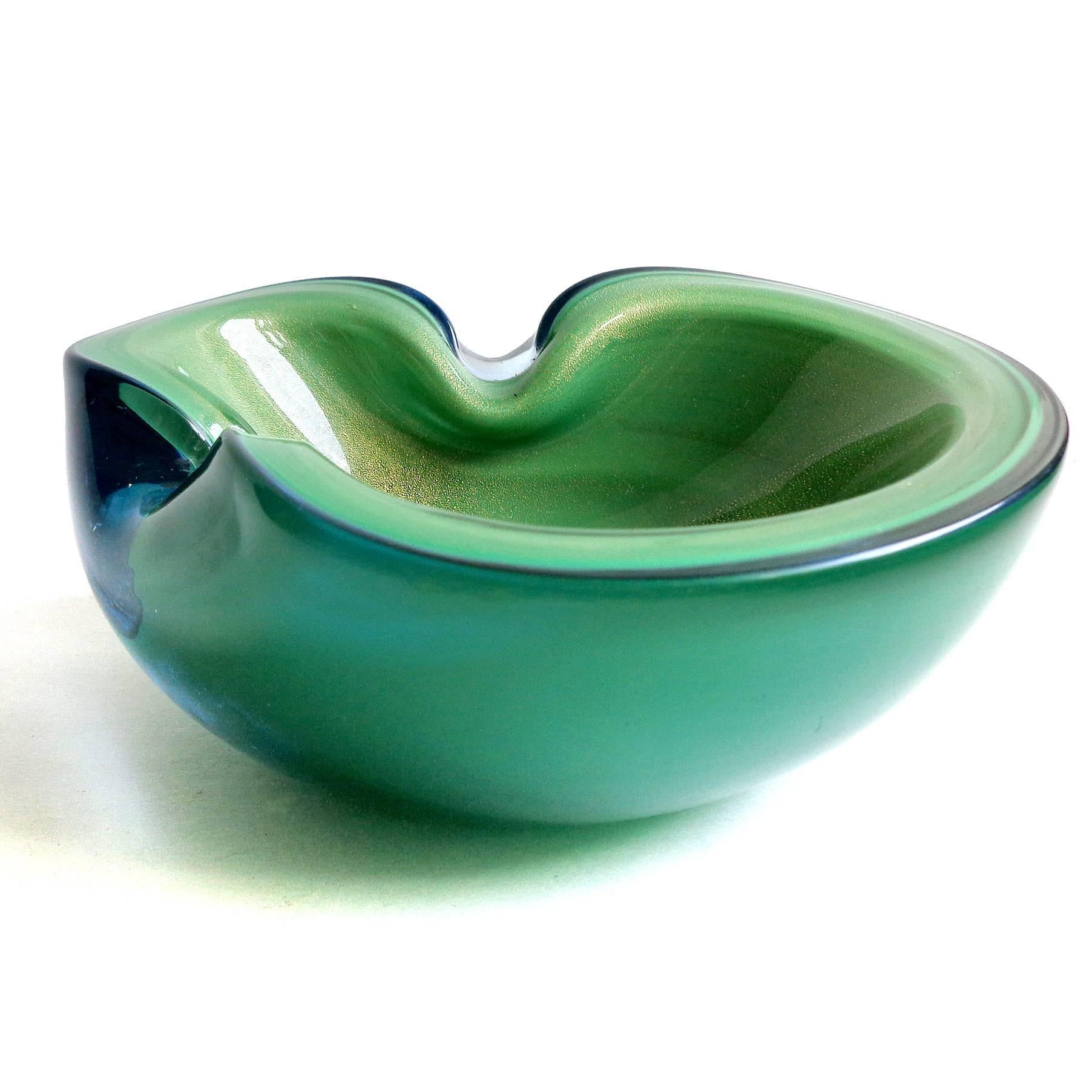 Beautiful Murano hand blown green and gold flecks Italian art glass bowl. Documented to designer Alfredo Barbini. Has two indents on the rim, and filled with gold leaf on the inside. A hint of clear blue on the outside clear layer. Beautiful