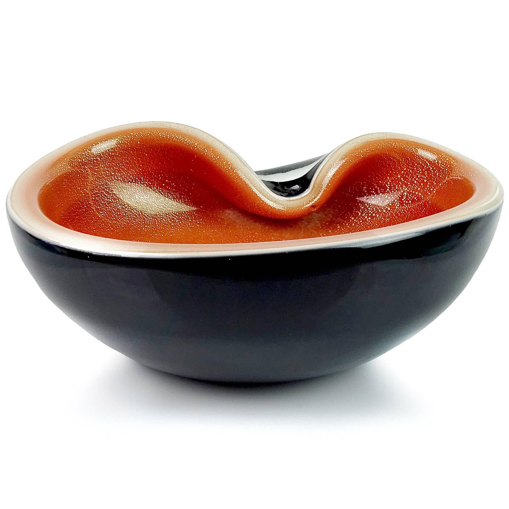 Beautiful Murano hand blown black over persimmon orange and gold flecks Italian art glass decorative bowl. Attributed to designer Alfredo Barbini. The piece has heavy gold leaf on the inside. Can be used as a display piece on any table. Use it as a