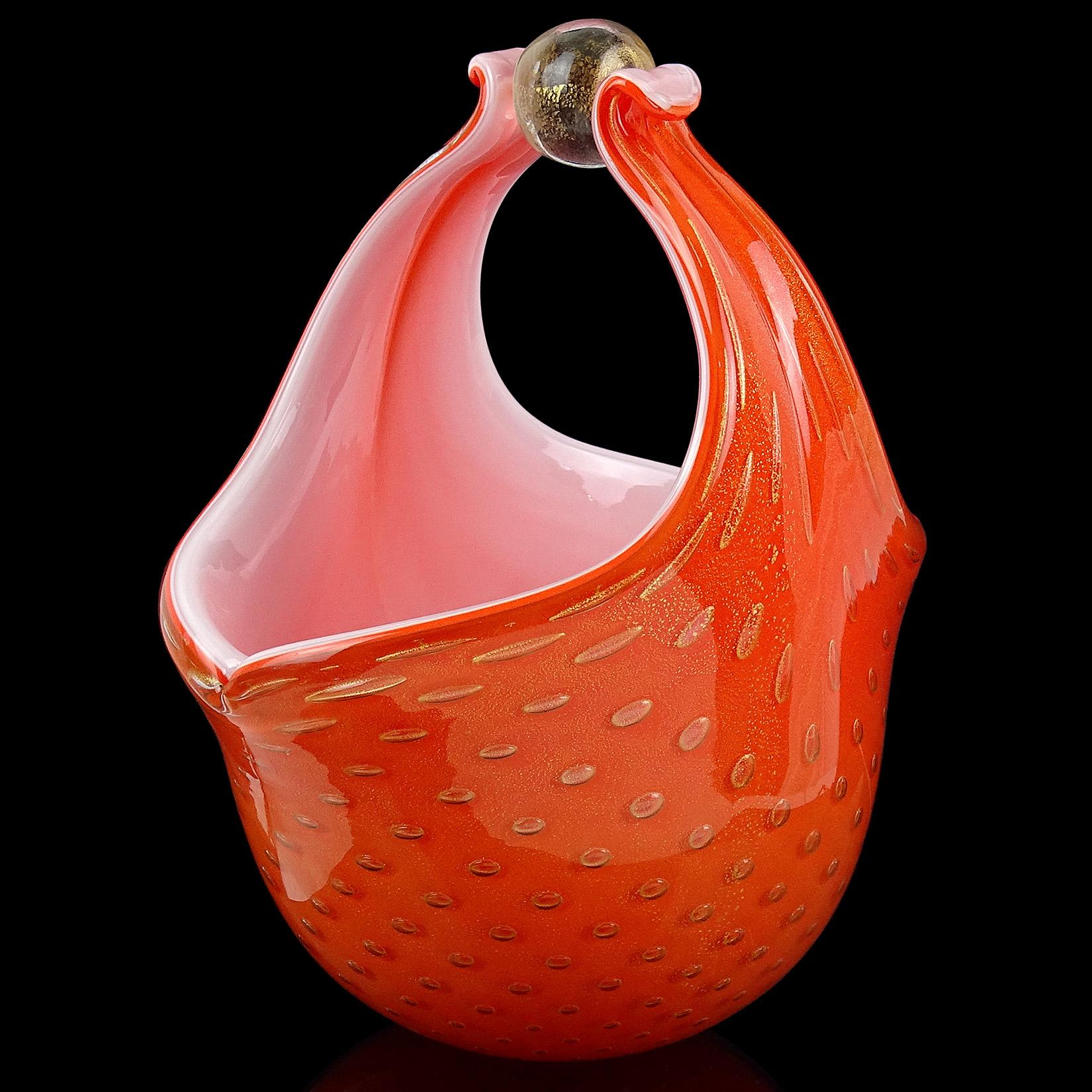 Beautiful vintage Murano hand blown orange, controlled bubbles and gold flecks Italian art glass flower basket / vase. Documented to designer Alfredo Barbini and published in his catalog, circa 1950-1960. It has 2 handles pulled up to the center,