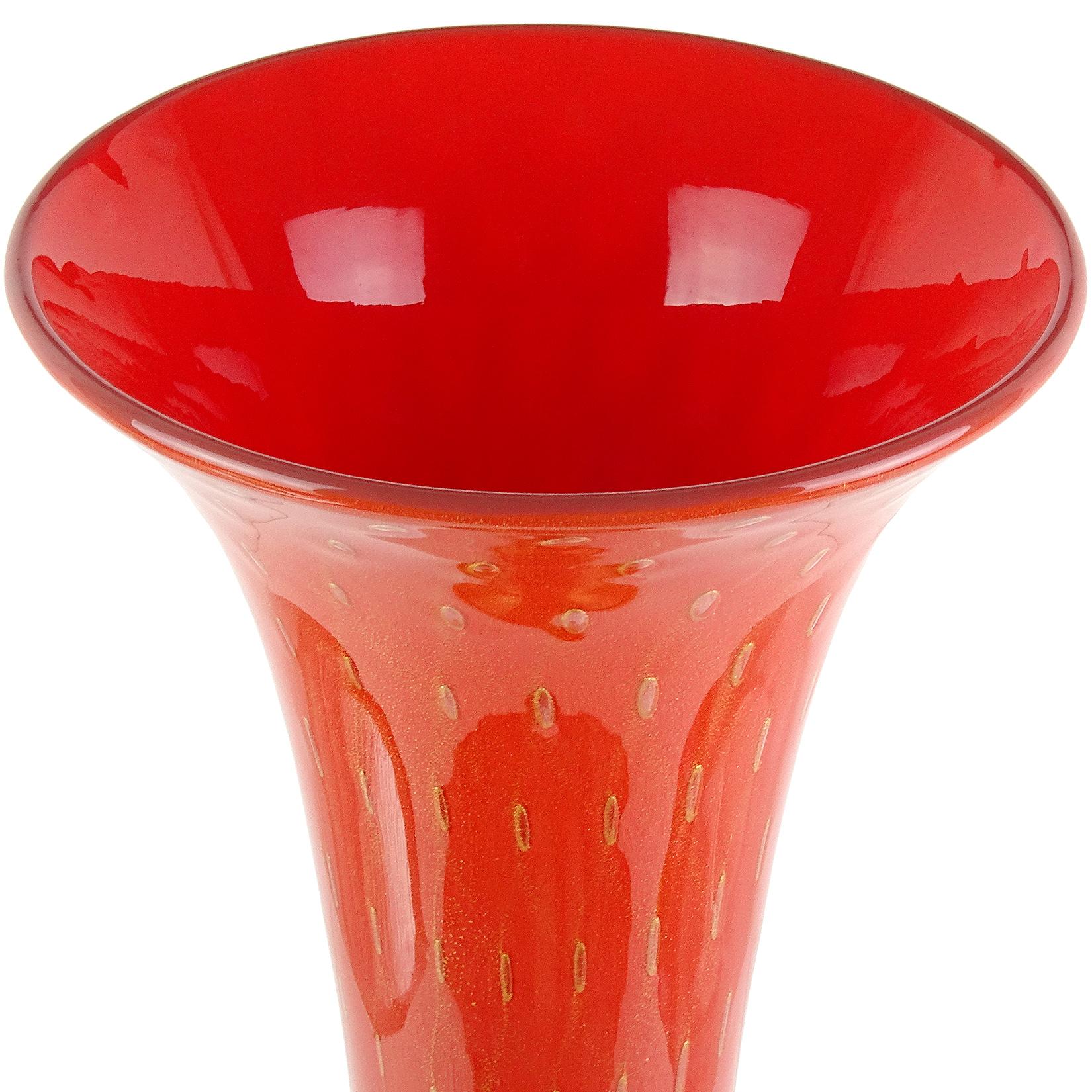 Beautiful tall vintage Murano hand blown persimmon orange, controlled bubbles and gold flecks Italian art glass trumpet flower vase. Documented to designer Alfredo Barbini and published in his catalog, circa 1950-1960. The entire piece is profusely