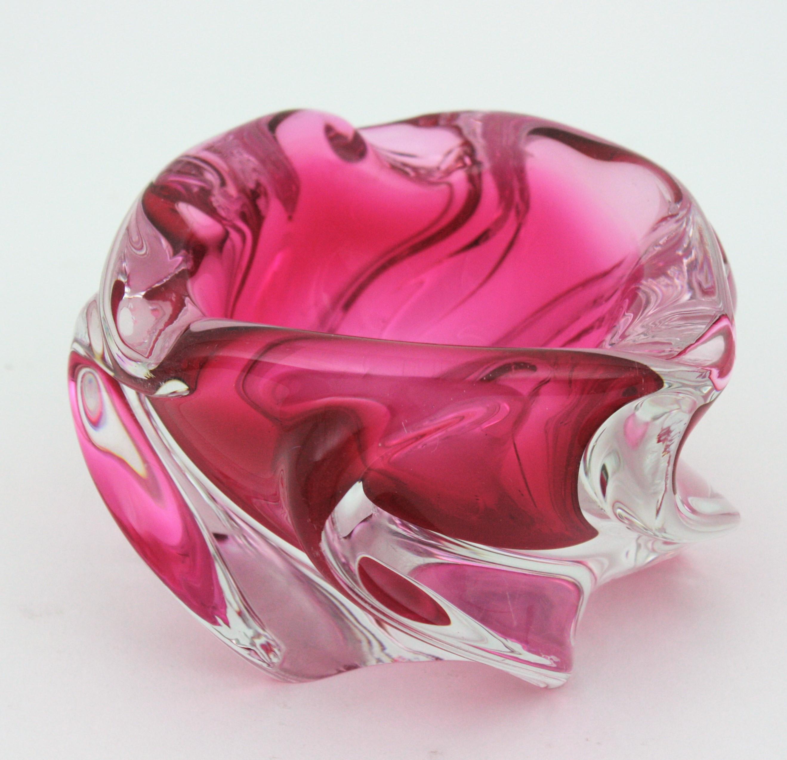 Handblown Murano glass pink and clear Sommerso twisted bowl or ashtray. Attributed to Alfredo Barbini. Italy, 1950s.
This organic shaped bowl is made with pink glass submerged into clear glass. It has a beautiful details with pulled glass creating