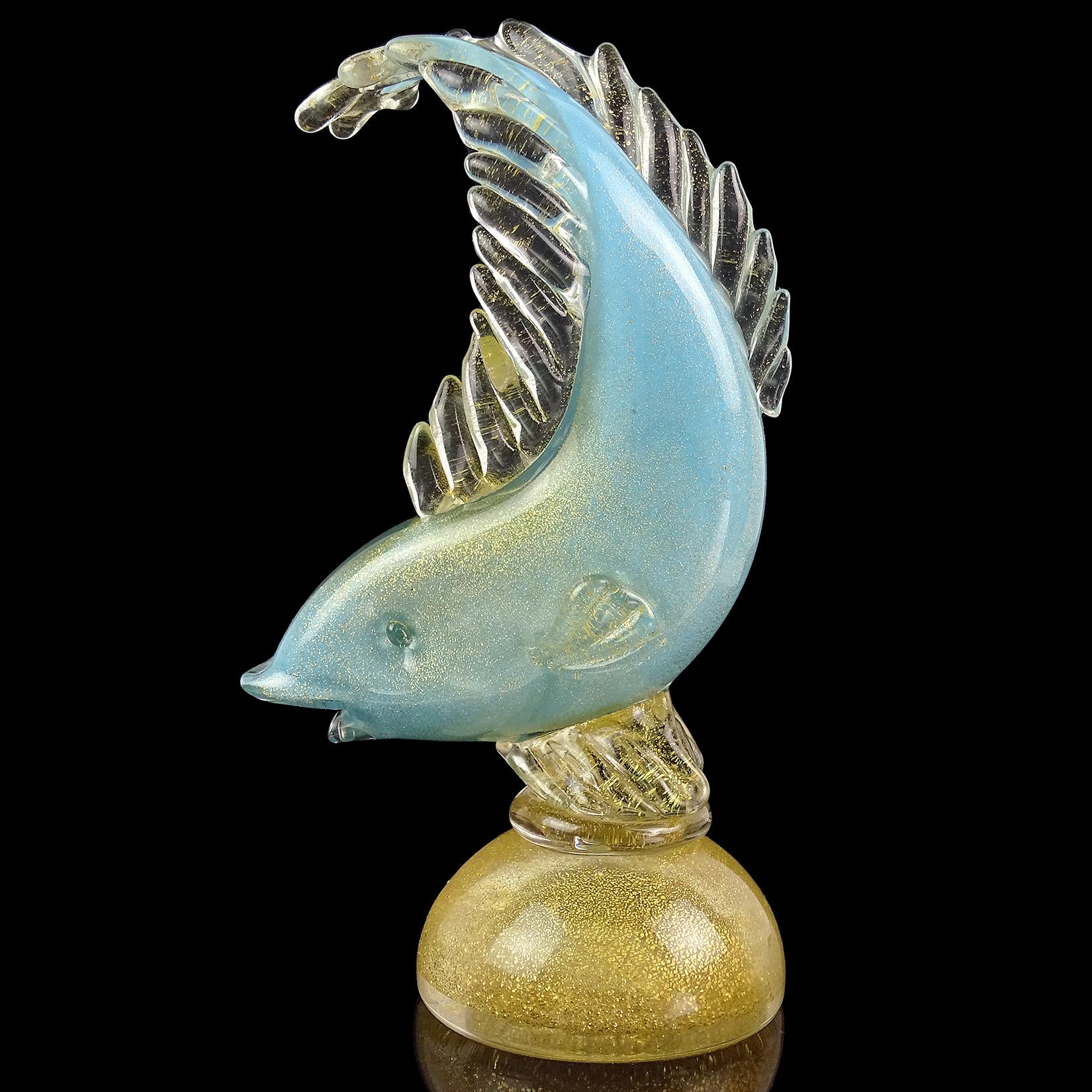 Beautiful vintage Murano hand blown sky blue and gold flecks Italian art glass fish sculpture / figurine. Documented to designer Alfredo Barbini. The leaping fish is profusely covered in gold leaf, and stands on a base with gold as well. Midcentury