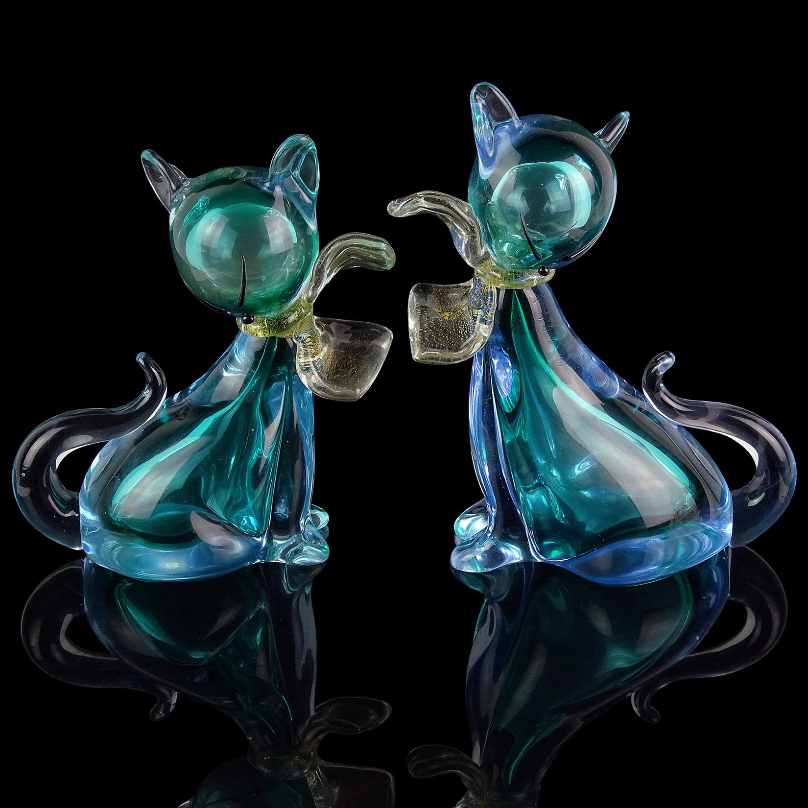 Beautiful Murano handblown Sommerso aqua blue and gold flecks art glass kitty cat figurines. Documented to designer Alfredo Barbini. The matching pair have gold leaf bows around their necks. Very elegant little kitties. Tallest measures 6 1/4