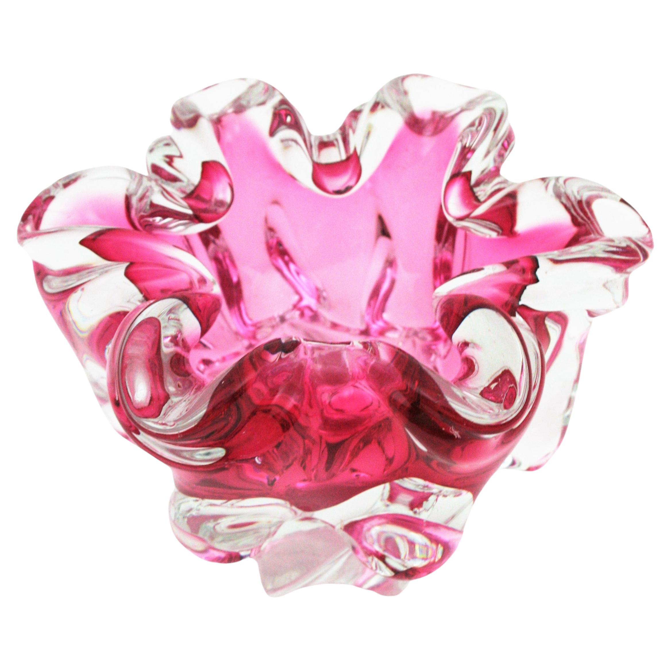 Handblown Murano glass pink and clear Sommerso footed bowl or ashtray. Attributed to Alfredo Barbini. Italy, 1950s.
This organic shaped bowl is made with pink glass submerged into clear glass. It has beautiful details with pulled glass creating