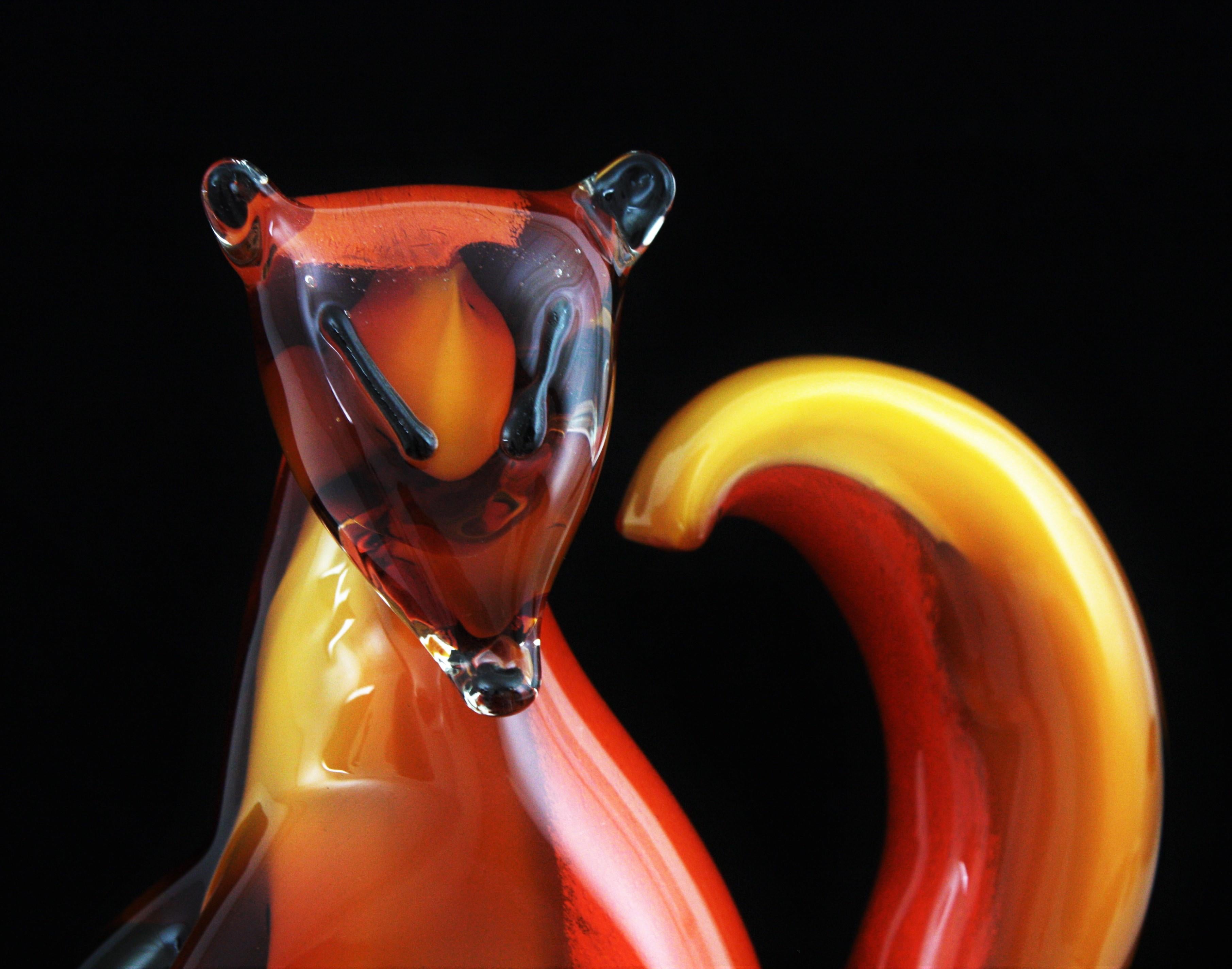 Scultura di scoiattolo in vetro soffiato a mano, unico nel suo genere, di colore ambra, arancione, bianco e trasparente, di Sommerso e Lattimo. Attribuito ad Alfredo Barbini, Italia, anni '50.
Questo simpatico scoiattolo in vetro di Murano ha un
