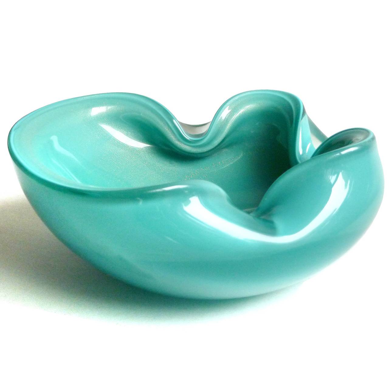 Beautiful vintage Murano hand blown teal blue/green and gold flecks Italian art glass bowl. Documented to designer Alfredo Barbini, circa 1950s. The bowl has theree indents on the rim, and filled with gold leaf on the inside. Can be used as a