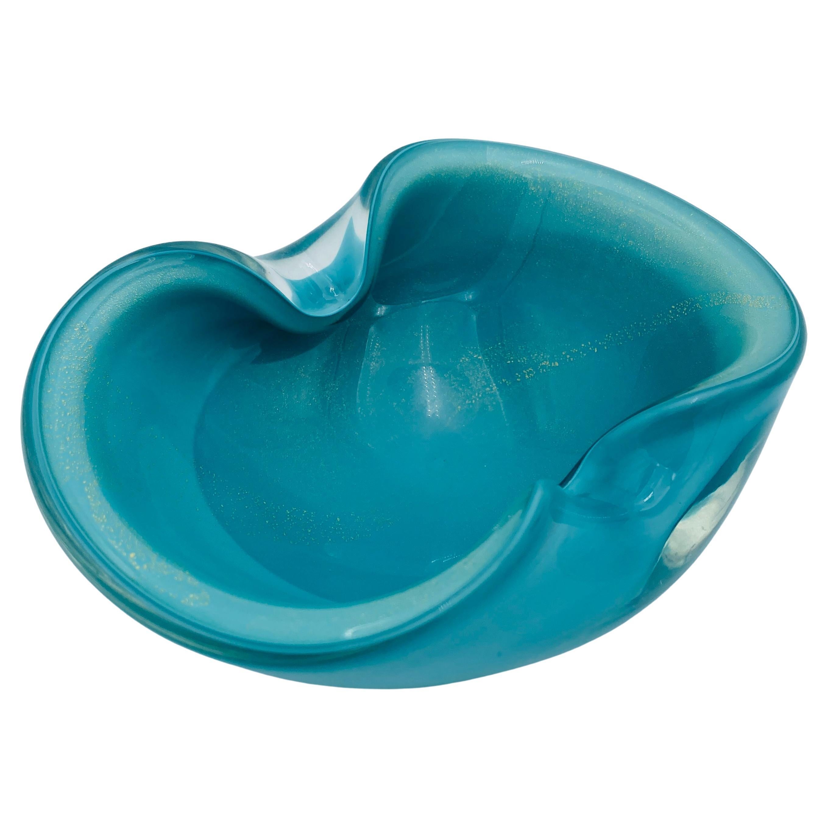 Beautiful vintage Italian Murano glass ashtray or bowl by Alfredo Barbini, circa 1960s. The handmade piece has two indents on the rim and is filled with gold leaf on the inside. The gold flecks shimmer, encased in the brilliant blue-green glass. It