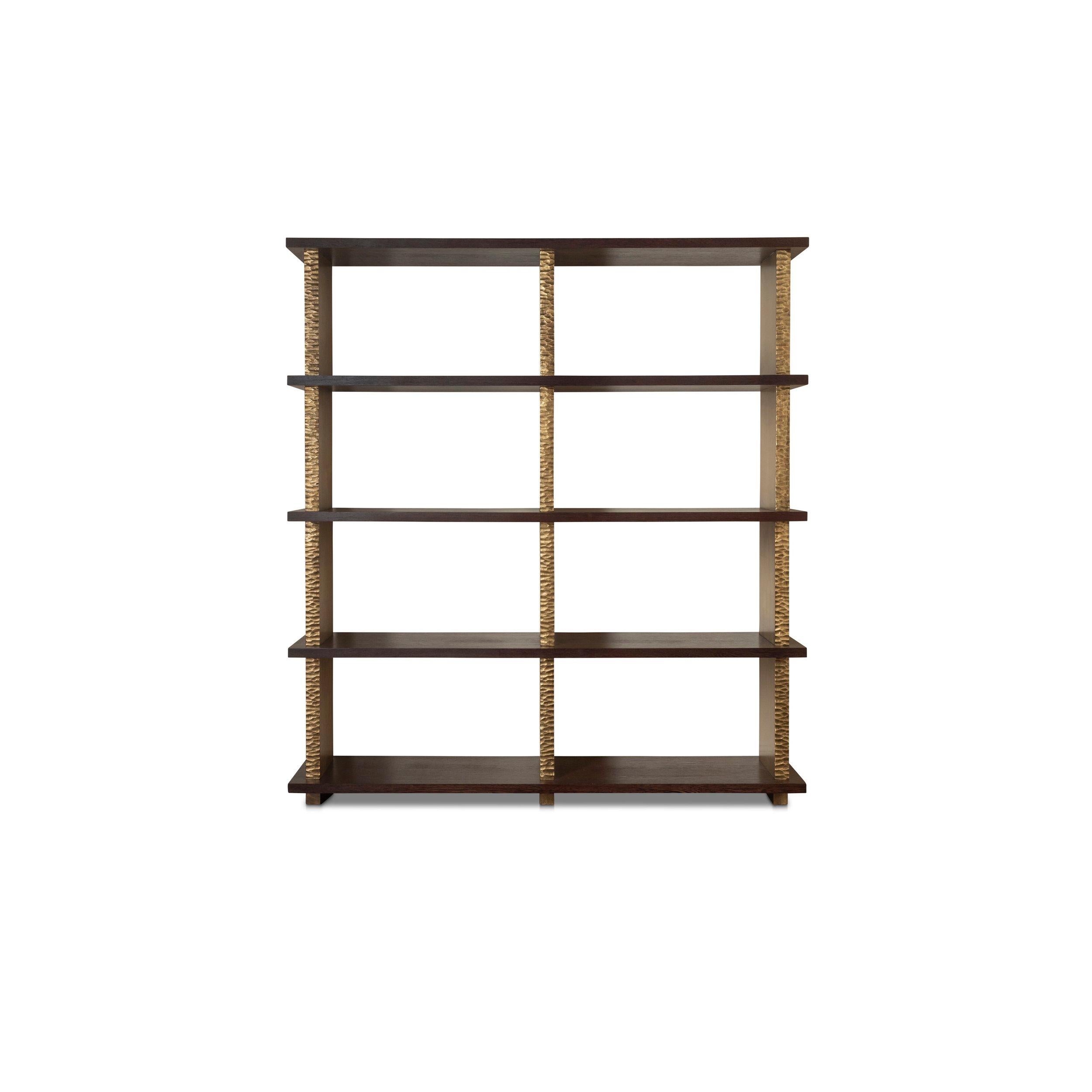 Una librería artesanal compuesta por tablones de rica madera de wengé apoyados en bloques tallados en astilla con acabado metálico. Funciona ingeniosamente tanto para guardarla como para exponerla.

- Remates de Resina Tallada con Estantería de