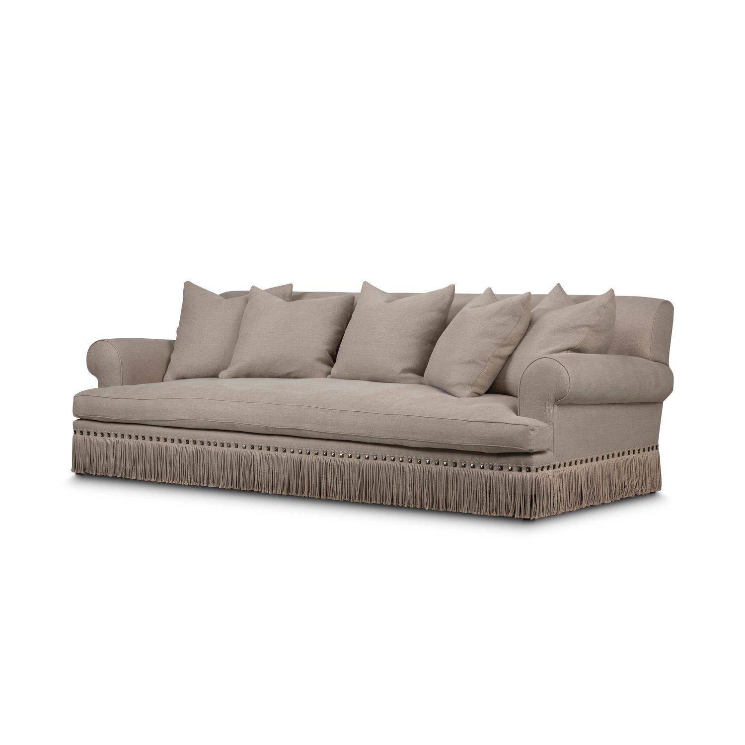 Une forme de luxe glamour des années quarante adaptée aux modes de vie décontractés d'aujourd'hui. Très profond et bas, avec des accoudoirs roulés légèrement inclinés, le meuble flotte sur un piétement en bois raffiné, ou peut être doté de riches