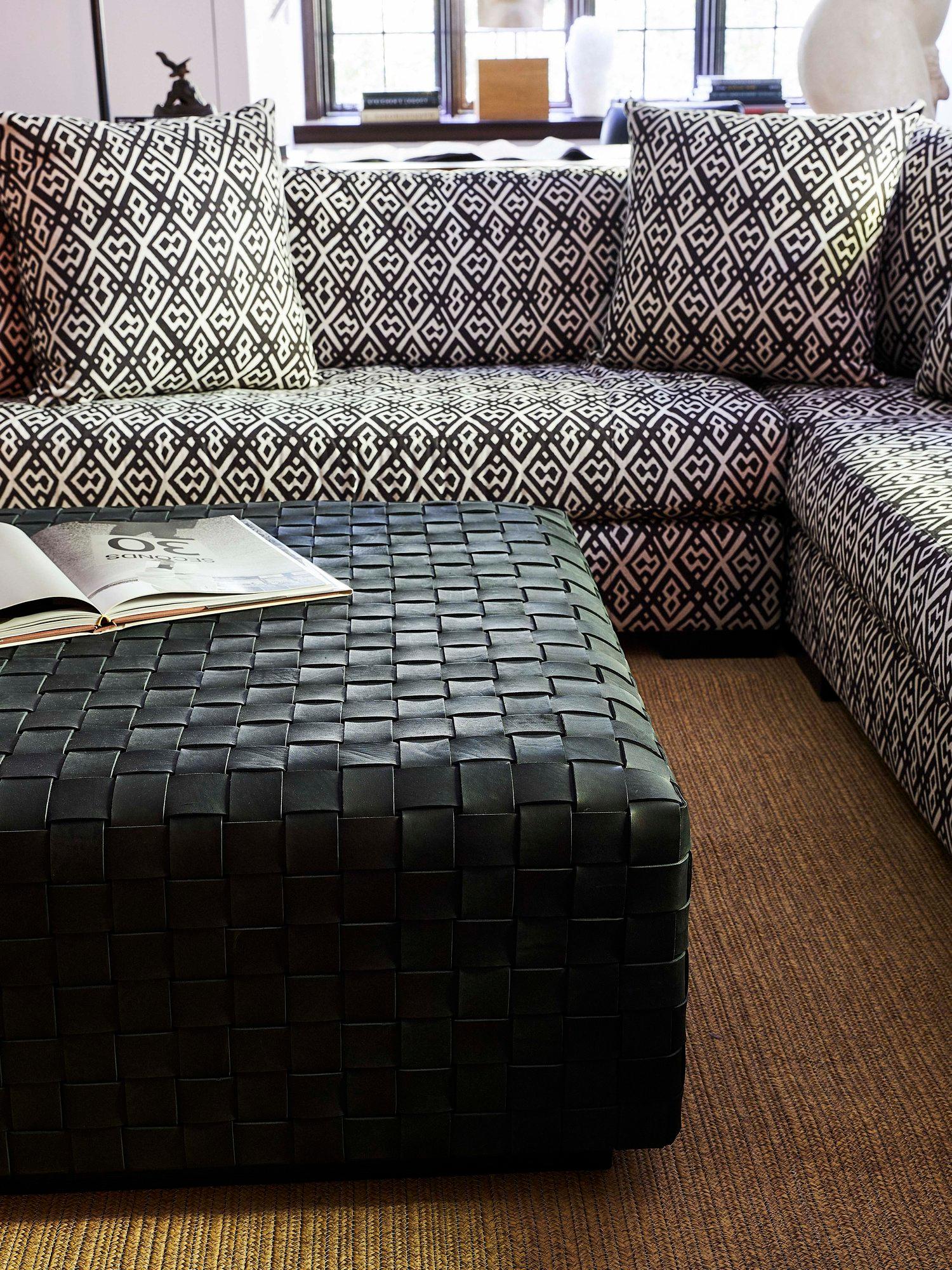 A sculptural form of boldly scaled woven belting leather crafted by skilled artisans, it serves as both a coffee table and ottoman (the surface is padded to sit upon).