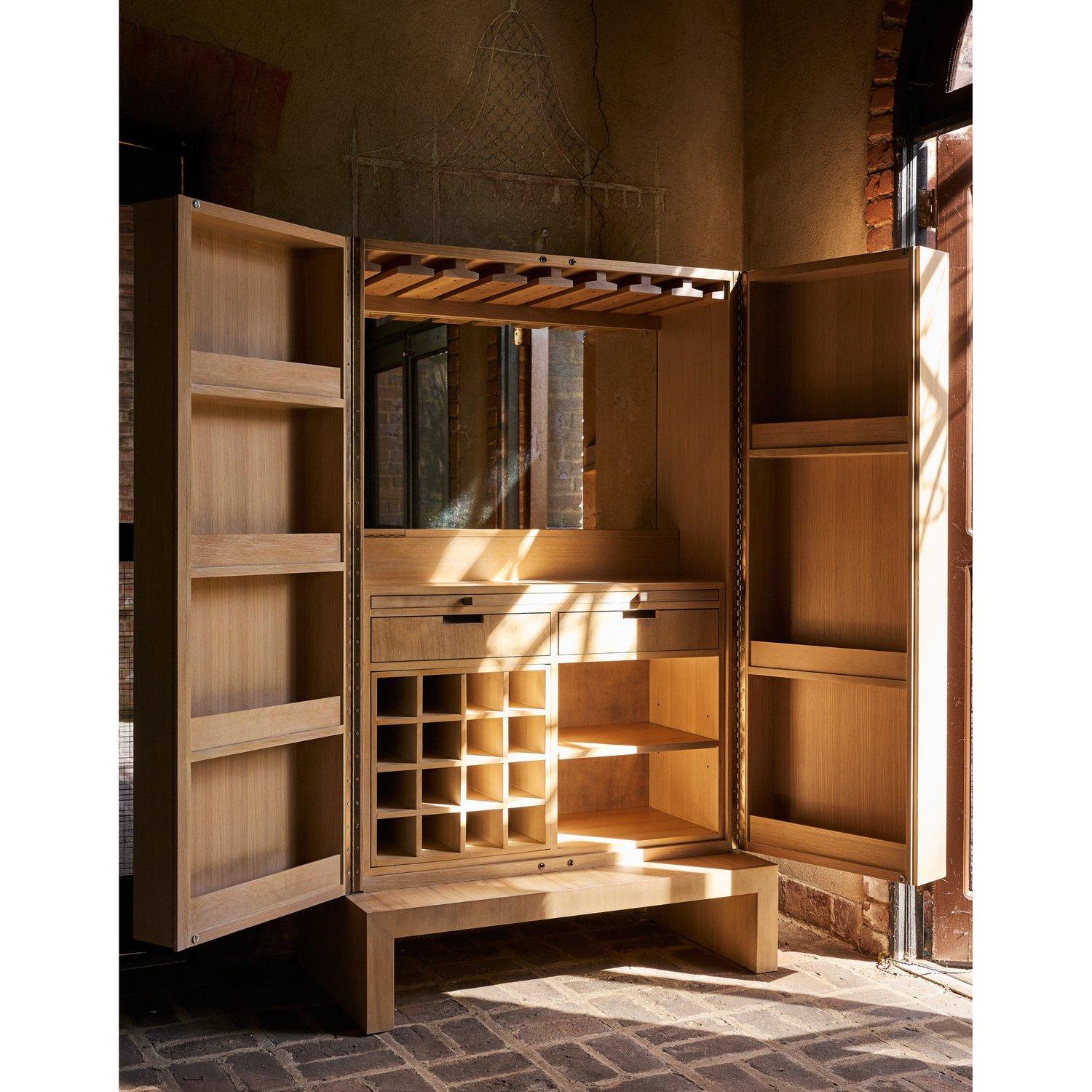 Progettato per essere un punto focale quando viene aperto o chiuso. La cassa contemporanea ha porte con un'insolita impiallacciatura a grana fine abbinata che nasconde un interno bar completamente attrezzato. La finitura in quercia color miele