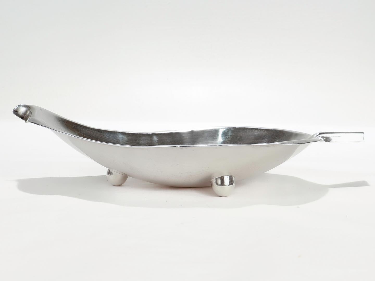 A fine American Modernist leaf bowl.

In sterling silver.

By Alfredo Sciarotta.

With an organic edge, 'stem' tab handle, and ball feet. 

Handmade in Sciarrotta's silver shop and retailed by Black, Starr, and Gorham. 

Simply a fine example of