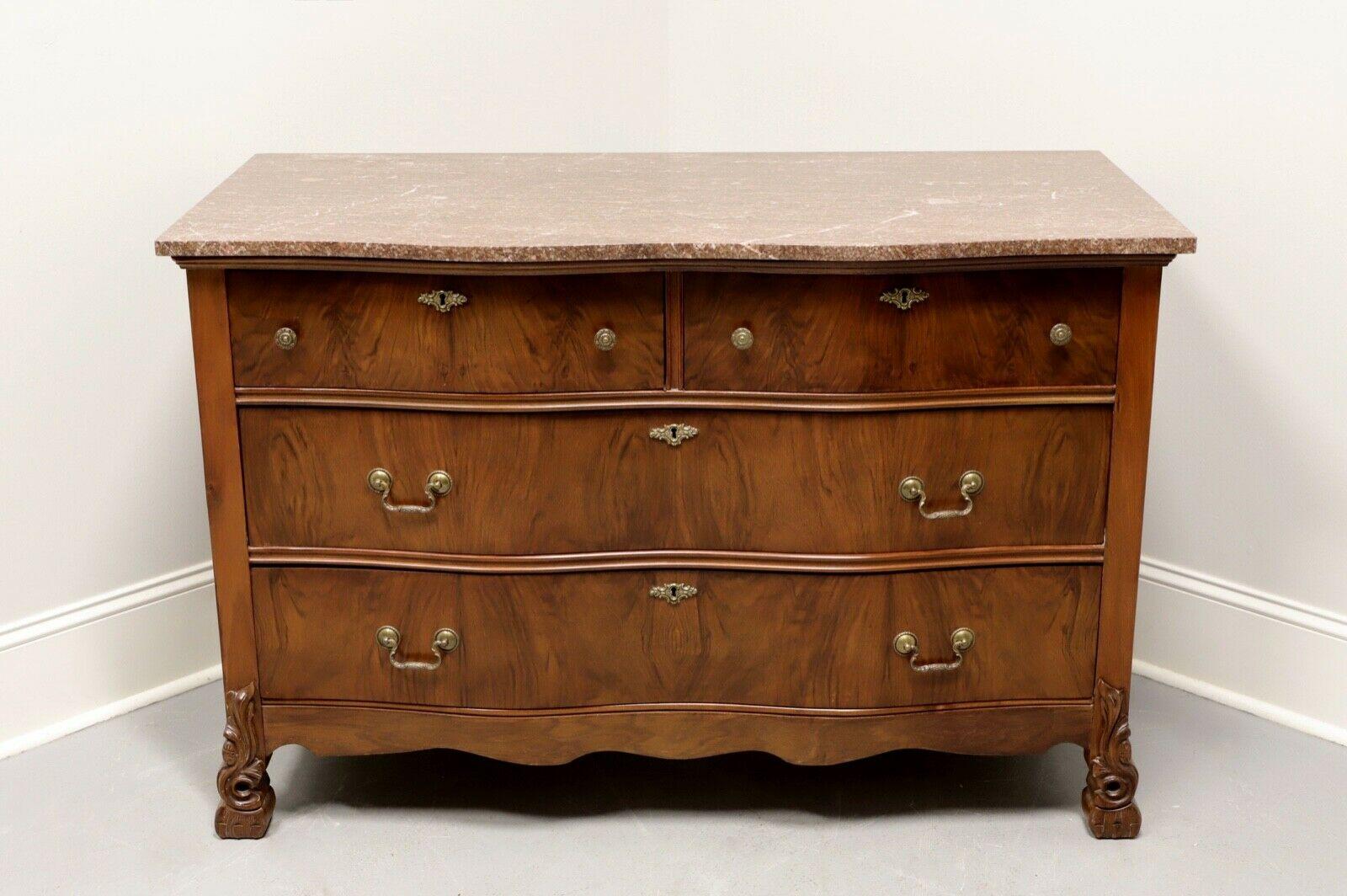 An antique French influenced North African style marble top chest, unbranded. Algerian oak with serpentine front, brass hardware, red/pink grained marble top and carved front feet. Features two smaller over two larger dovetail drawers with faux