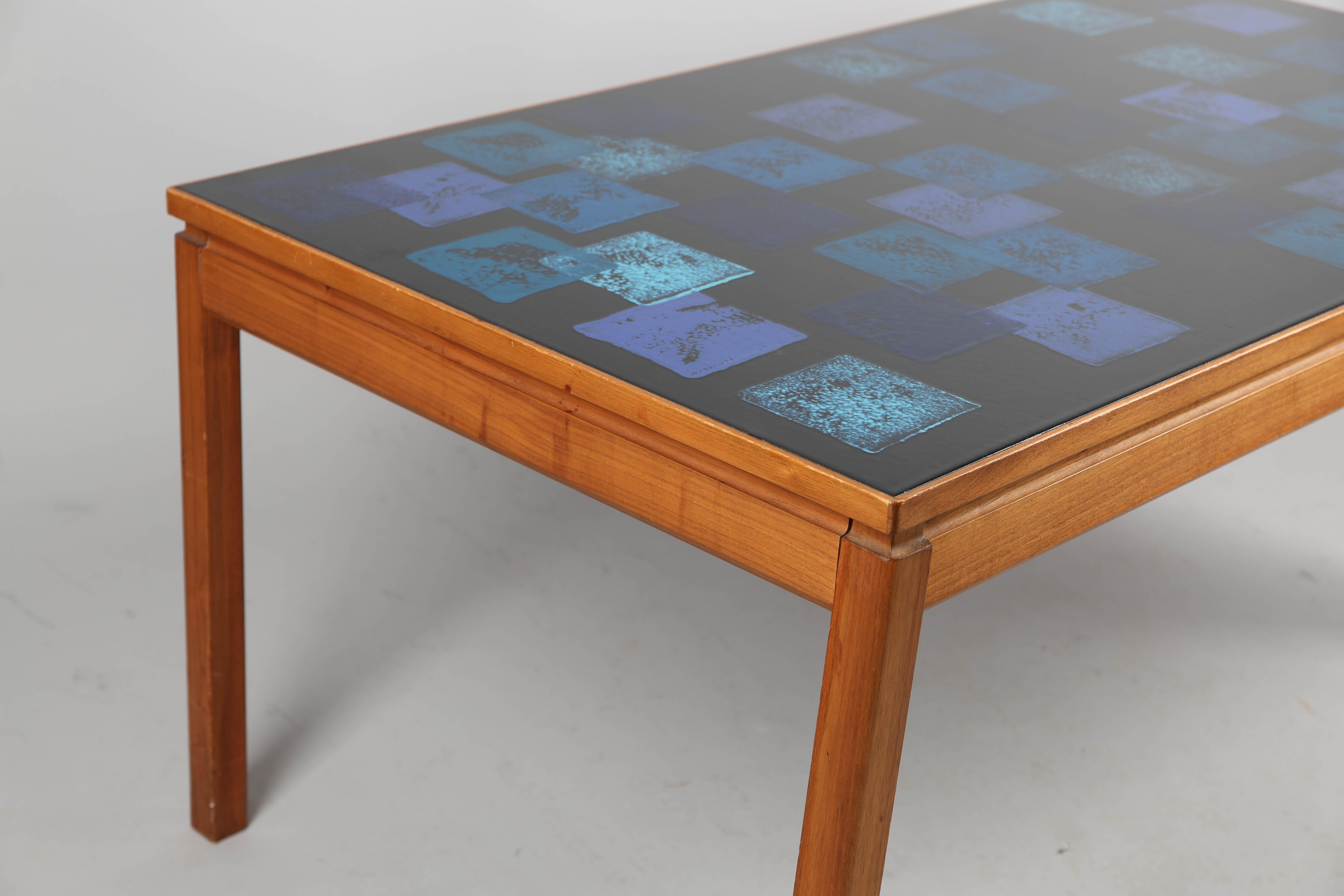 Table basse en émail bleu sur cuivre et teck par P. Torneman (Algot Törneman).
Châssis en teck  fabriqué par Saffle Möbelfabrik en Suède vers 1960
Dimensions 120x65 cm, hauteur 52 cm.
Édition rare. P. Törneman était le fils du peintre suédois
