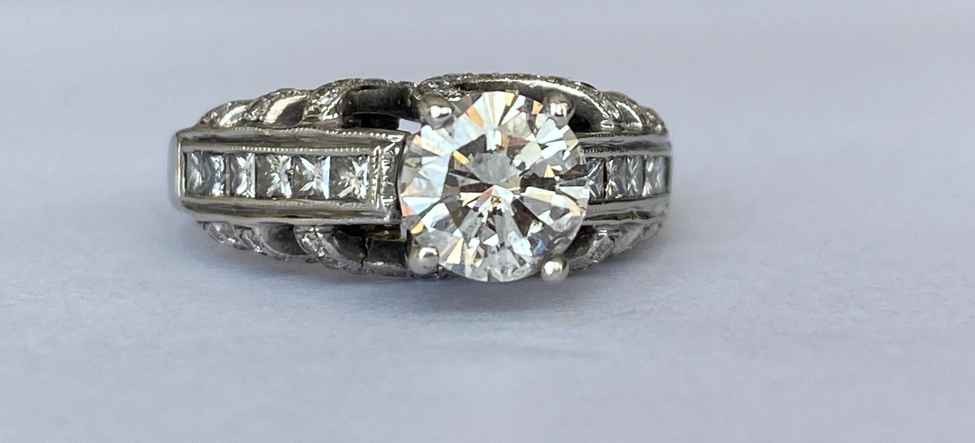 Offered 18 carat white gold solitaire ring with a 1.20 ct brilliant cut diamond of quality L Faint Gray/P1 and 70 stones  brilliant and princess cut diamonds in total approx. 1.00 ct G/M/VVS/SI. Total: 2.20 crt  ALGT certificate is included. Number