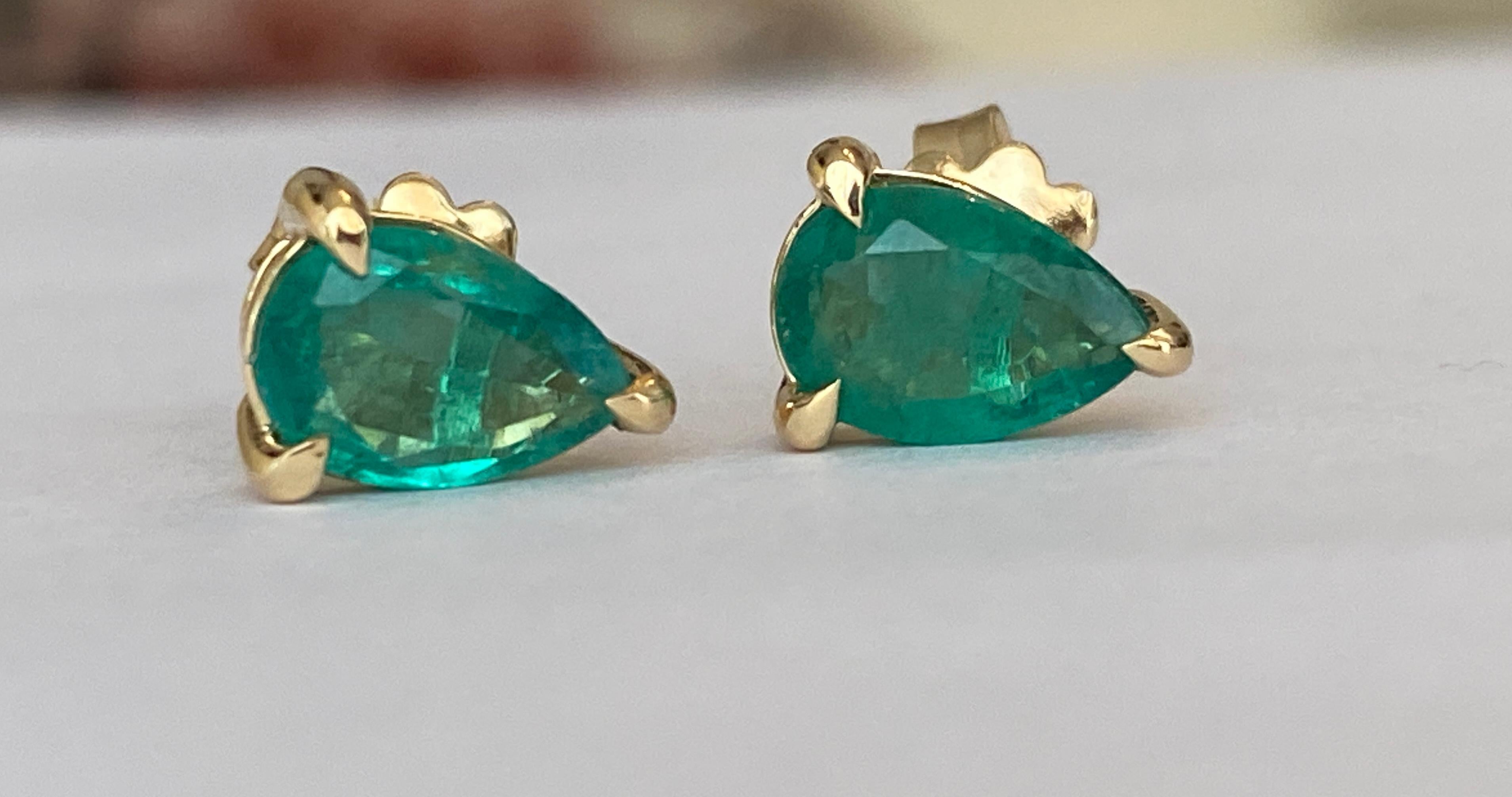 Elaborados en radiante oro amarillo de 18 quilates, estos elegantes pendientes colgantes exhiben esmeraldas en forma de pera que destilan una sofisticación atemporal. Las esmeraldas, conocidas por su exuberante tono verde y su brillo natural, se