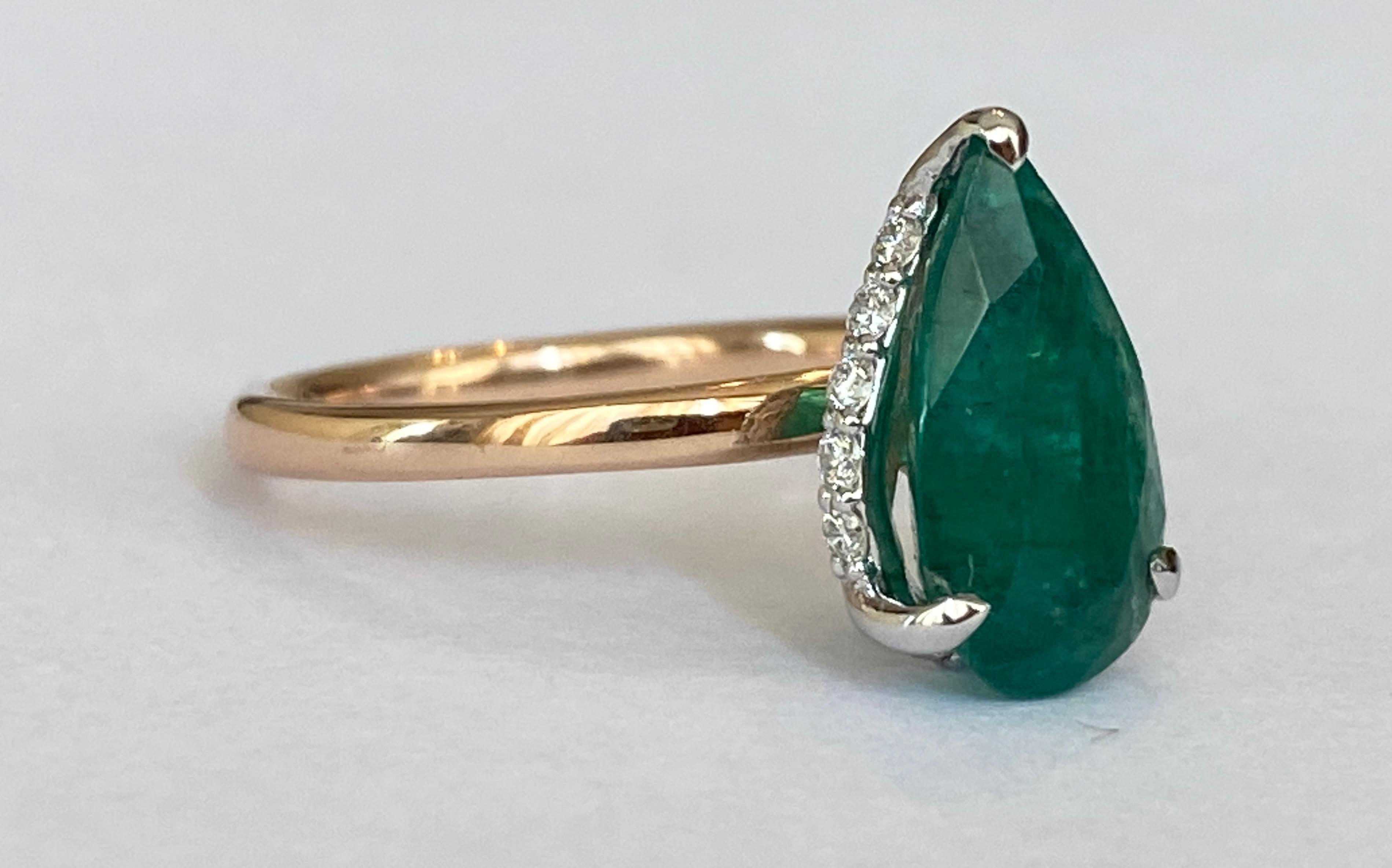 Offered in new condition, an 18 carat handmade Bi-color ring with a natural pear mixed cut emerald of 3.00 crt in the center, surrounded by 13 pieces of brilliant cut diamonds totaling approximately 0.16 crt of quality F/G/VS. The color of the