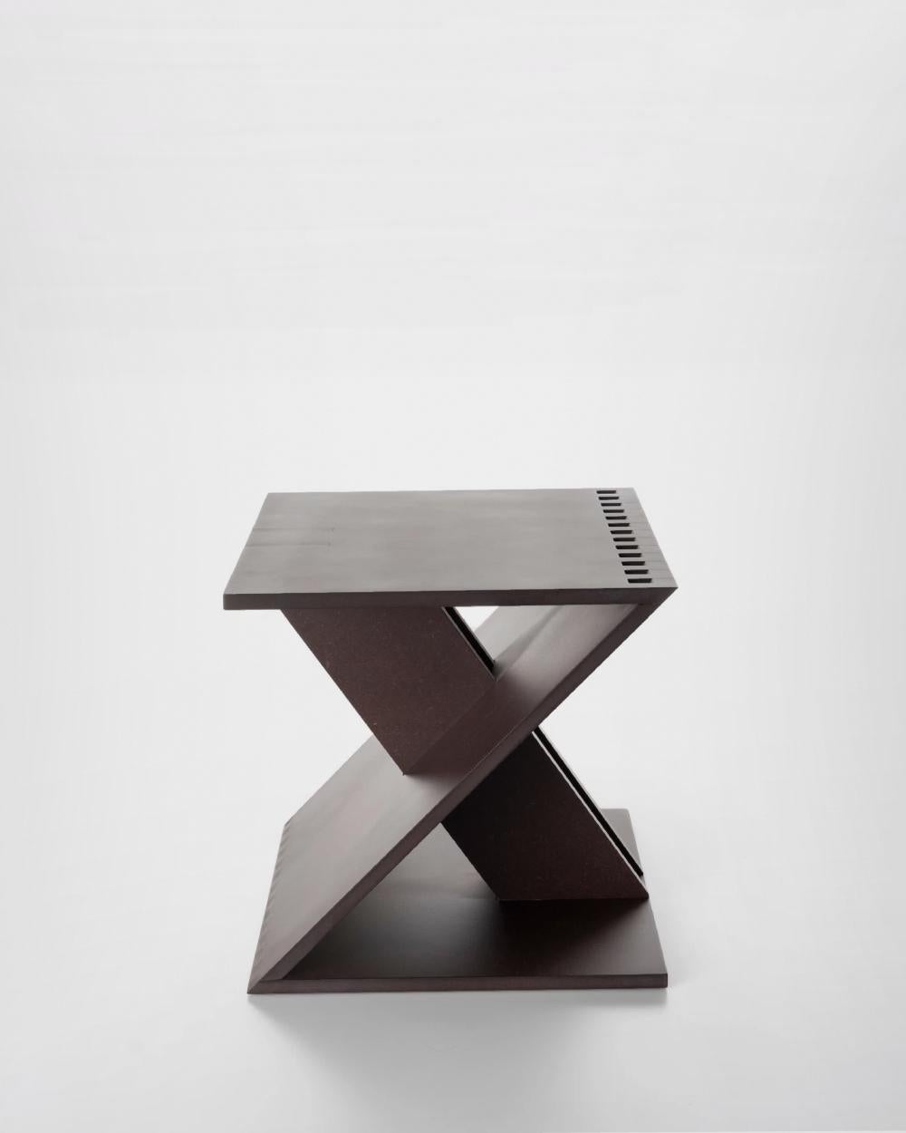 Le tabouret Zeta rappelle la lettre dont il tire son nom : deux éléments carrés, servant de base et d'assise, sont reliés par un élément diagonal fixé par un joint en peigne à chaque extrémité. Deux feuilles diagonales se fondent dans cet élément,