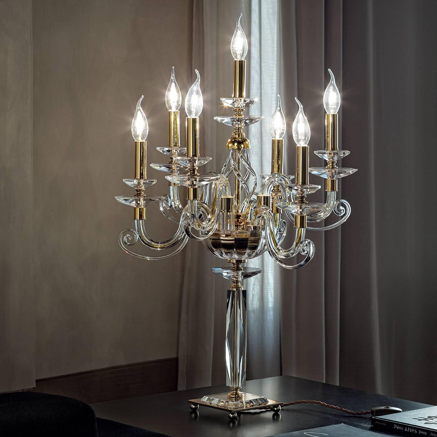 This elegant, seven-branched candelabra is part of the Alicante collection which features exquisite lighting pieces made of clear glass with gold accents decorated with Swarovski crystal. A sophisticated piece of formal decor, it is a striking