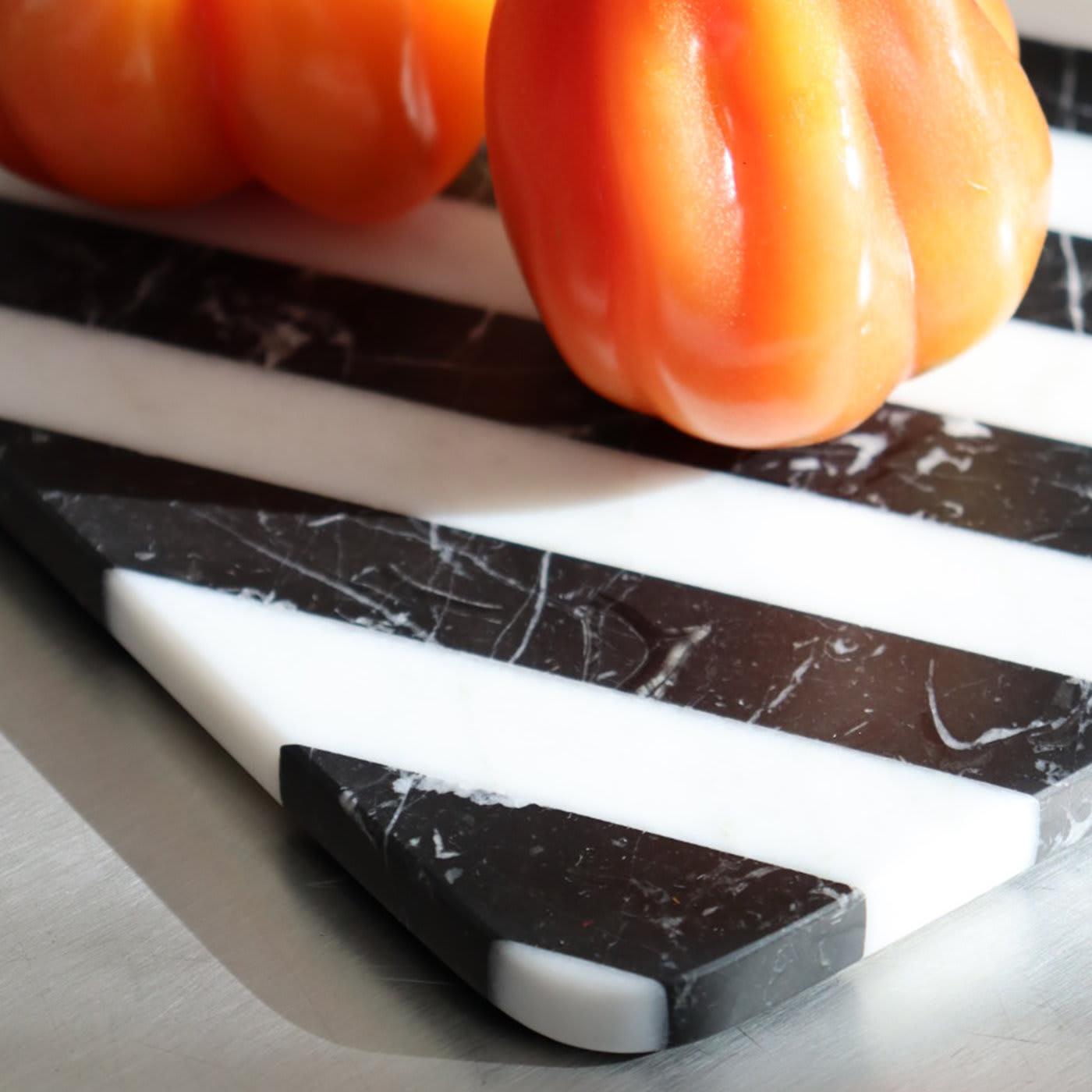 Bold in its versatility, this exceptional chopping board exudes sculptural appeal and modern elegance. The rectangular silhouette is handcrafted of white Arabescato and black Marquina marbles, the striped pattern reminiscent of the dramatic