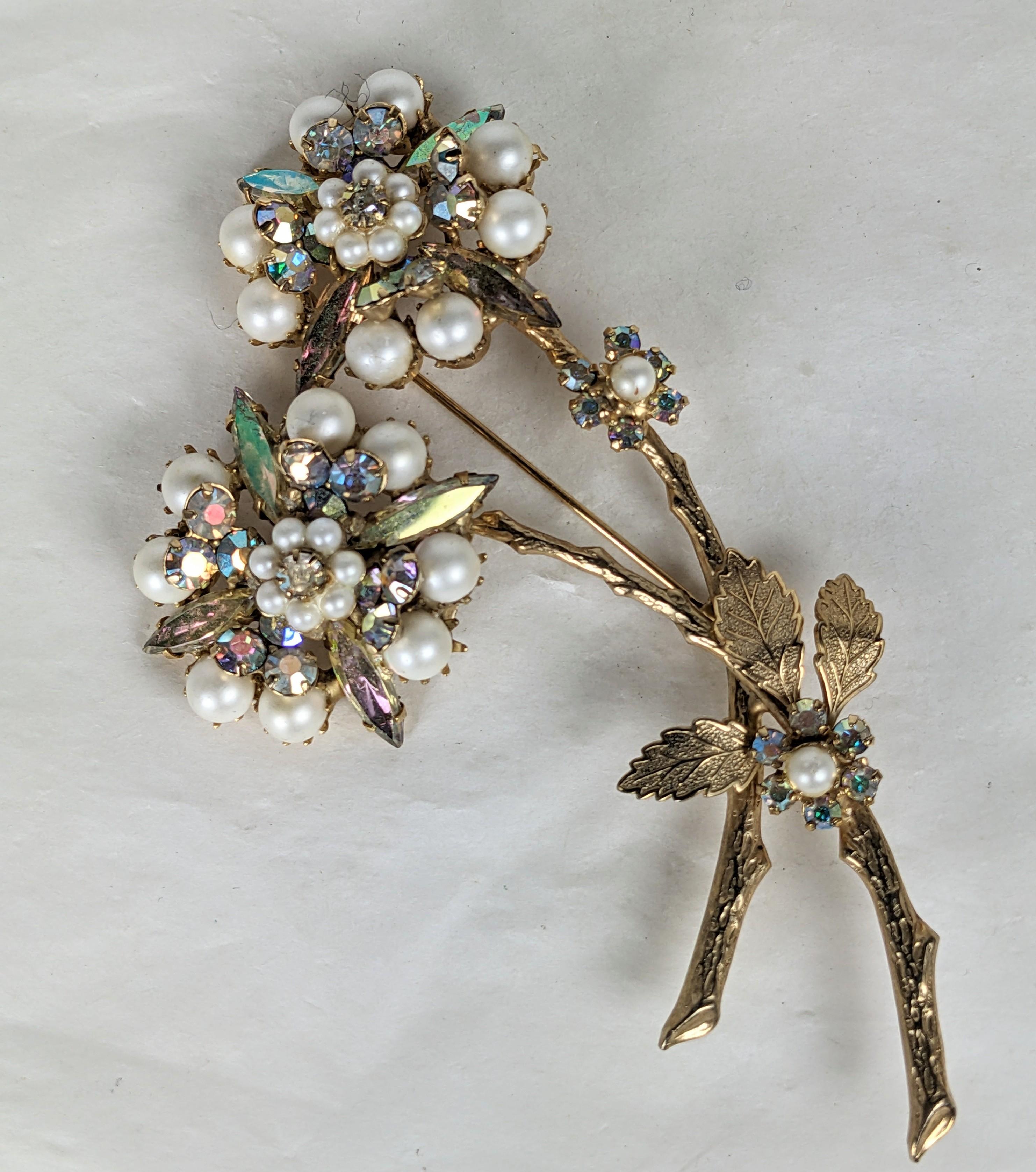 Alice Caviness Floral Aurora and Pearl Spray Brooch from the 1950's. Large gilt spray with 2 large flowerheads of faux pearls and Aurora crystal Marquises. Small accent flowers on branch. 
Signed. 4
