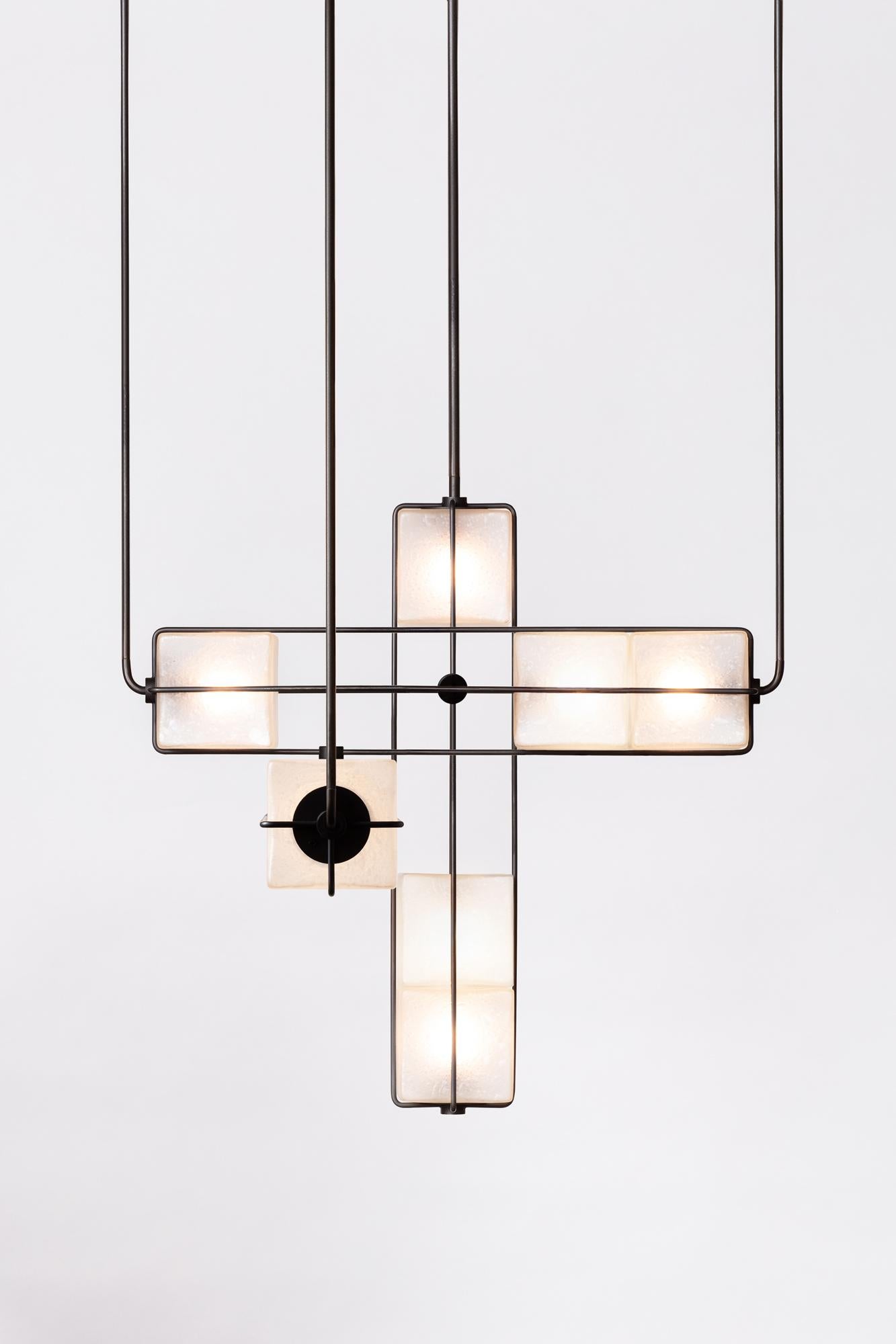 The Alice collection is inspired by Brutalist modular architecture. The textured hand blown glass cubes are sandblasted to create a soft glow and stacked together to diffuse light in different intensities. The frame is made of solid brass, finishes
