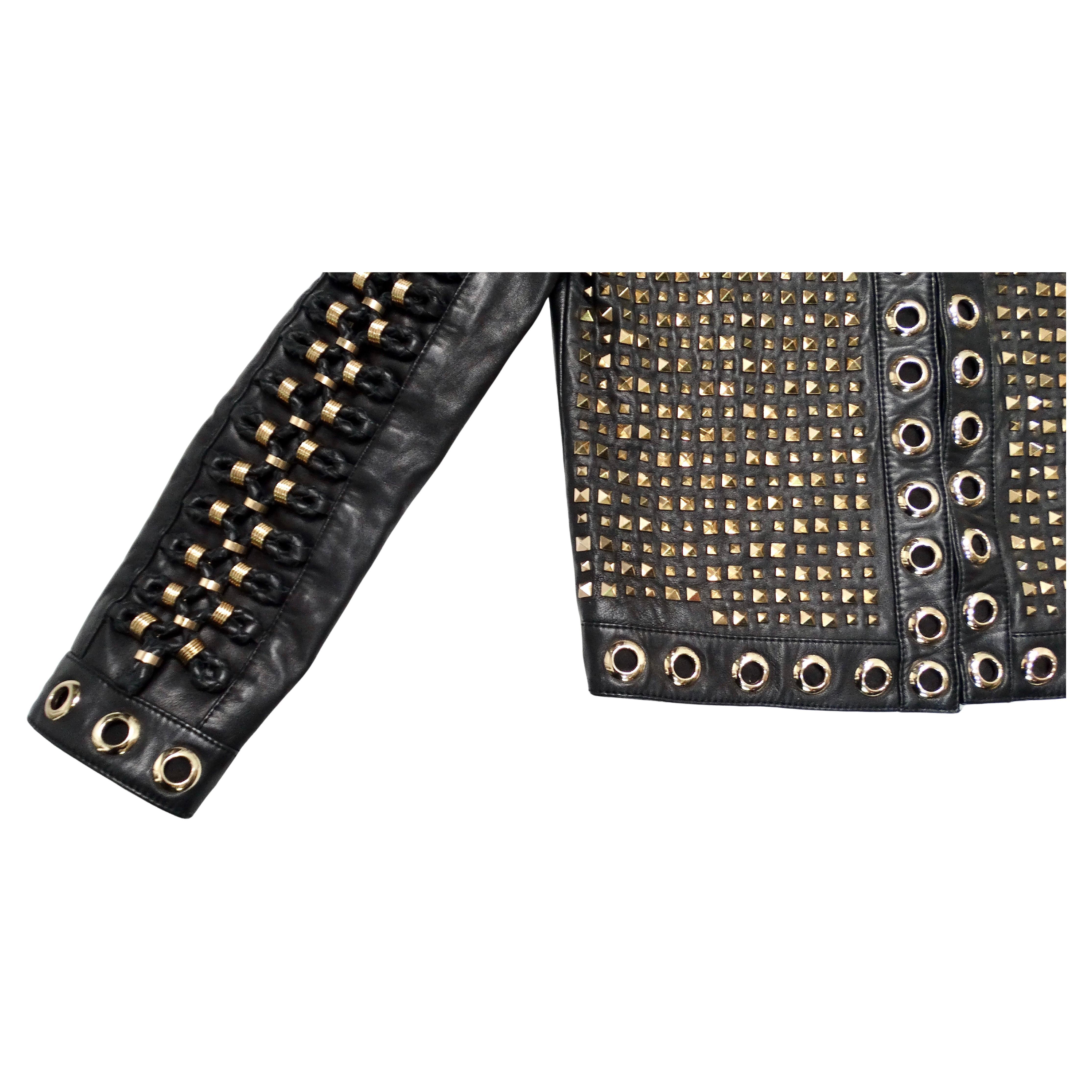 The Alice + Olivia Black Lambskin Leather Rockstud & Grommet Embellished Jacket is a striking statement piece that exemplifies edgy sophistication. Crafted from luxurious black lambskin leather, the jacket features an all-over pattern of gold-tone