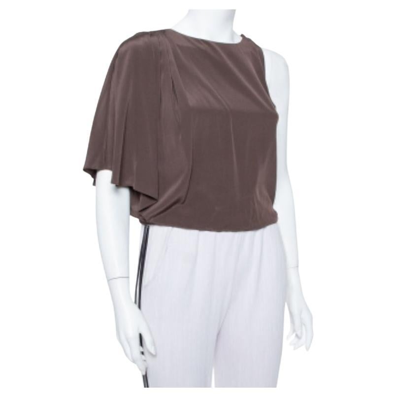 Flaunt high style with this brown top by Alice + Olivia. The chic creation has been made from 100% silk and designed in an asymmetrical silhouette with draped details on the right shoulder while the left one is sleeveless. It comes equipped with a