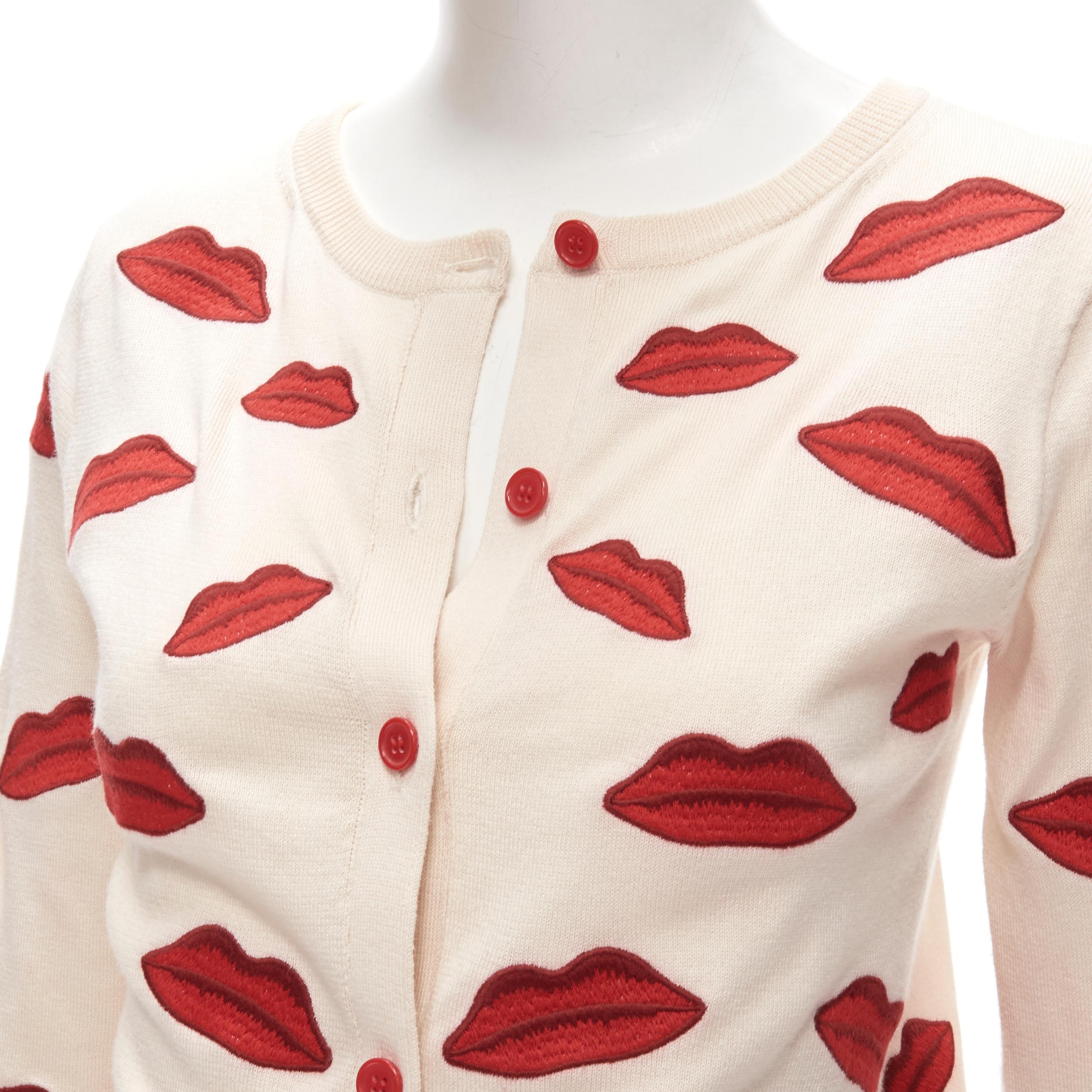 ALICE OLIVIA Signature red lip embroidered badge applique cardigan S 
Reference: ANWU/A00716 
Brand: Alice Olvia 
Color: Beige 
Pattern: Lips 
Closure: Button 
Extra Detail: Red button closure. 

CONDITION: 
Condition: Excellent, this item was