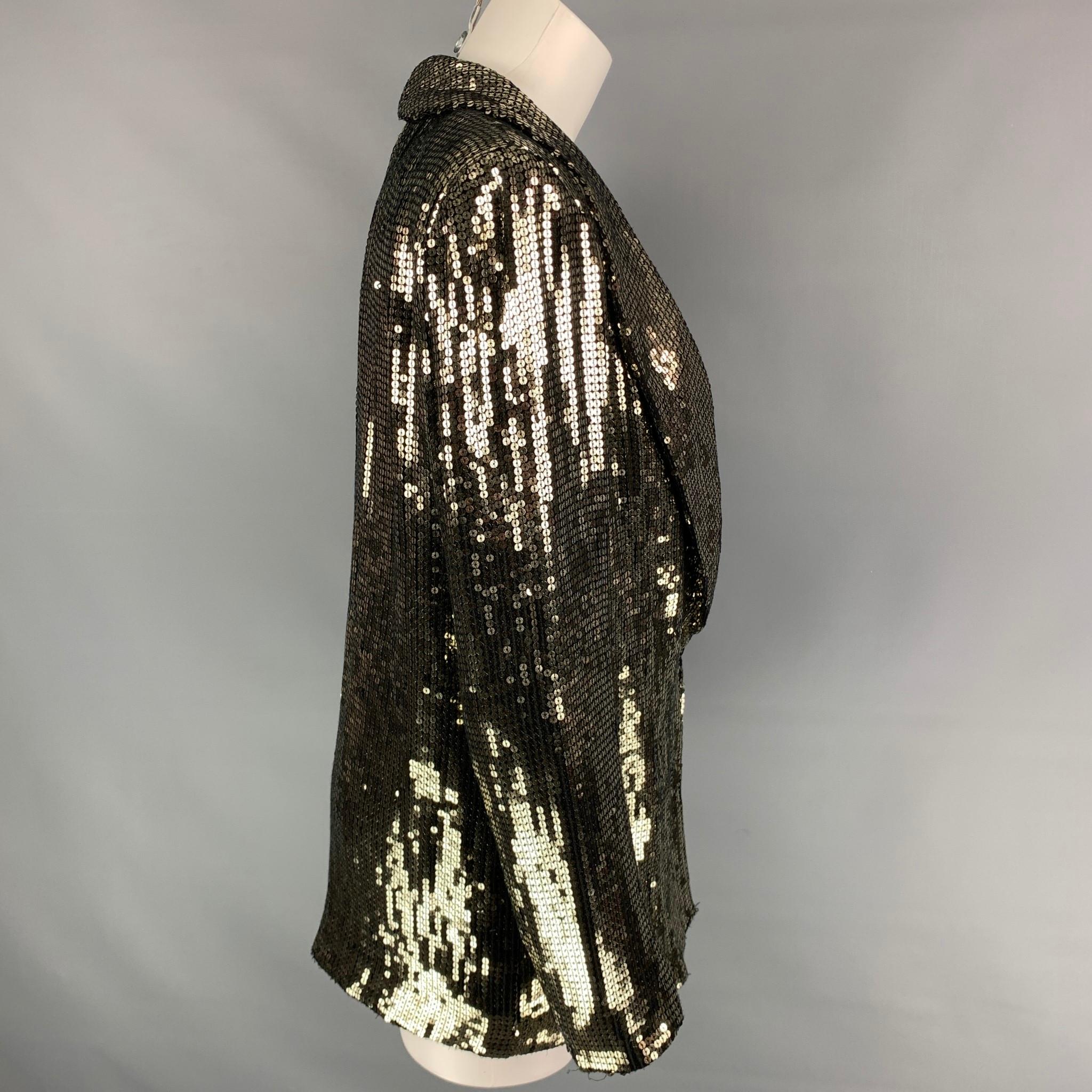 ALICE + OLIVIA jacket comes in a gold sequined viscose with a full liner featuring a shawl collar, slit pockets, and a double hook & loop closure. 

Very Good Pre-Owned Condition.
Marked: S
Original Retail Price: $595.00

Measurements:

Shoulder: 15