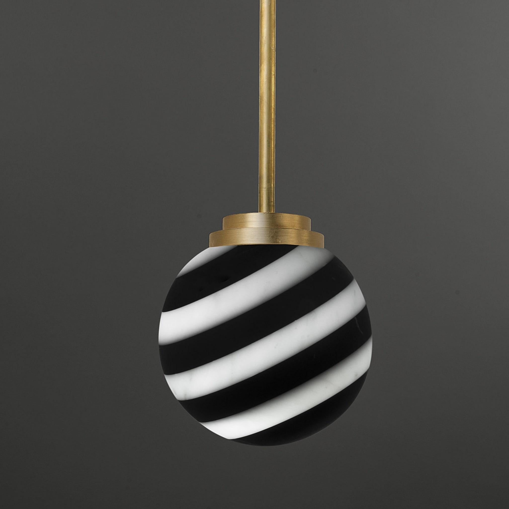 An ode to minimalist design sensibility and architectural rigor, this captivating pendant lamp by Bethan Gray draws inspiration from the 12th-century Cathedral in Siena. The orb-shaped pendant boasts a striped black-and-white pattern crafted using