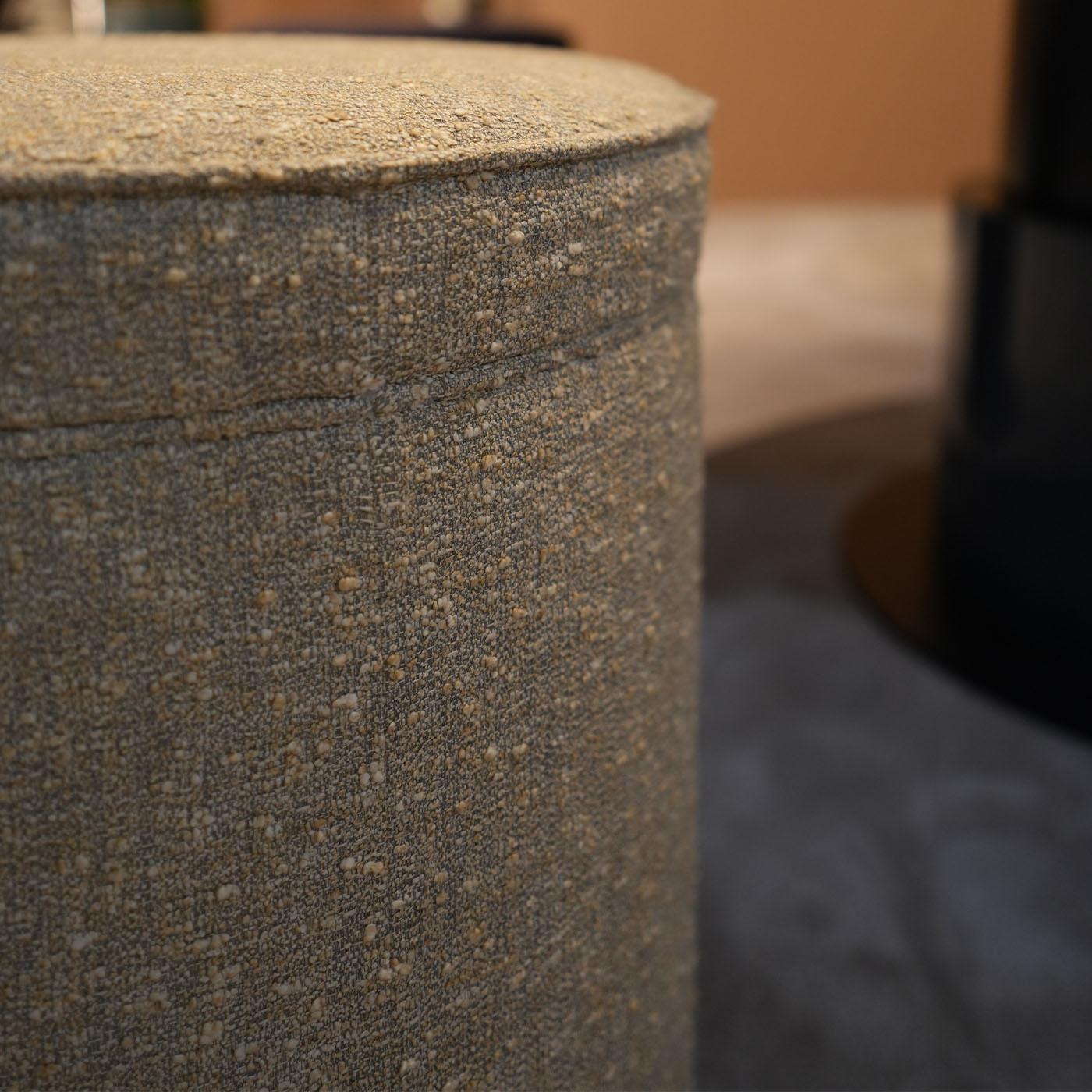Utmost comfort and simplicity merge in this compact pouf, refined modern design precious as an occasional seat in a living room, walk-in closet, or bedroom, alike. An extra-soft melange gray fabric envelops its cylindrical silhouette, sealed by a