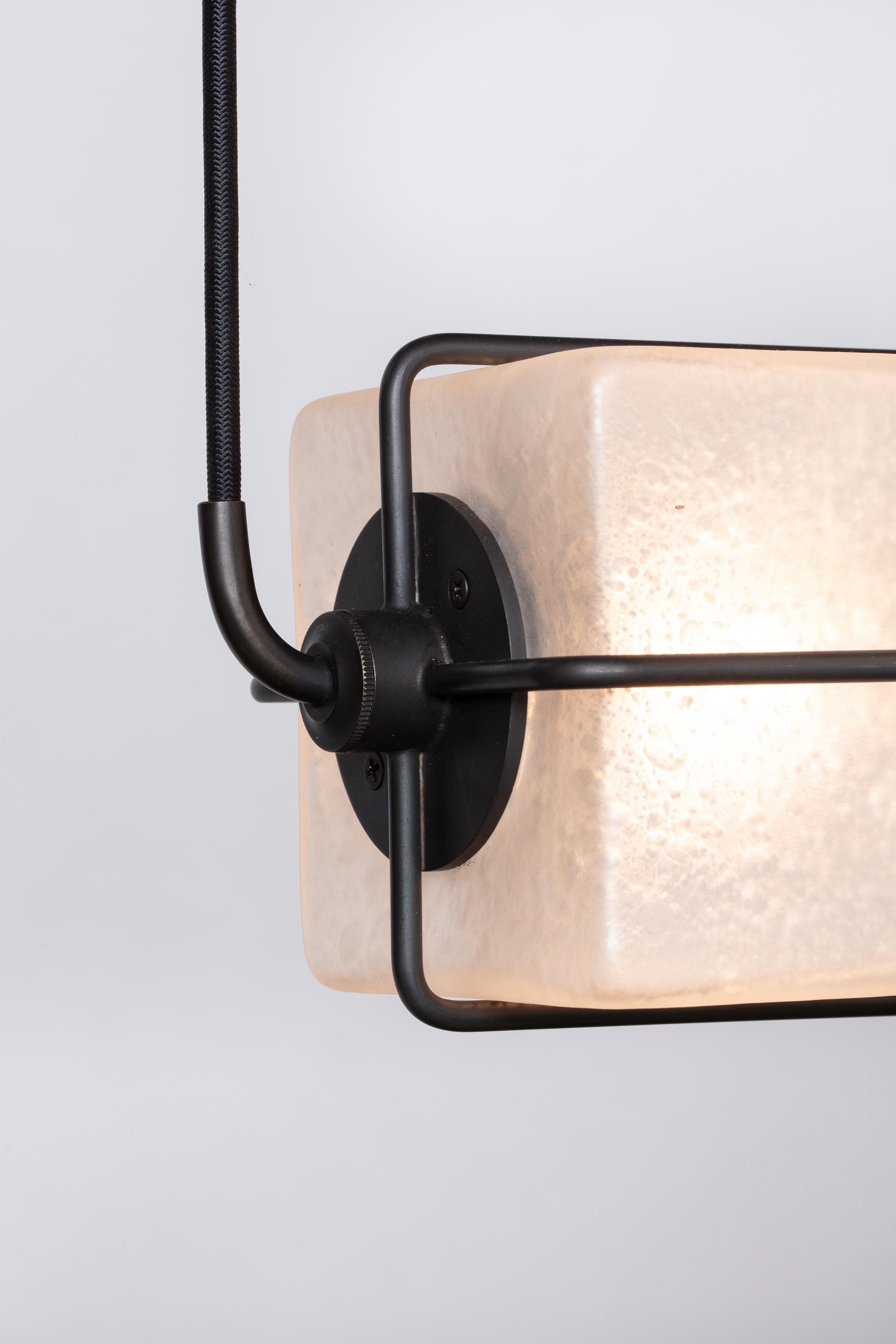 The Alice collection is inspired by Brutalist modular architecture. The textured hand blown glass cubes are sandblasted to create a soft glow and stacked together to diffuse light in different intensities. The frame is made of solid brass, finished