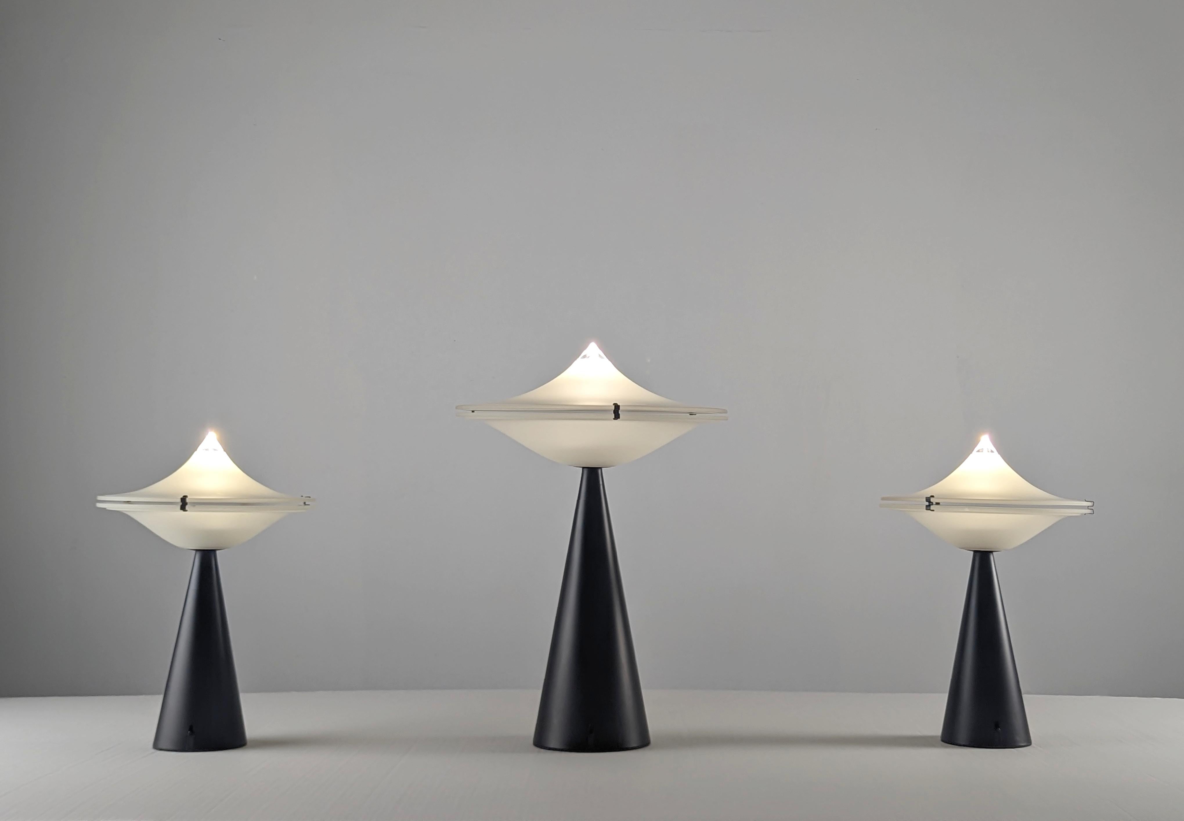 Wunderschönes Set aus drei Alien-Lampen, entworfen von Cesaro L., mit einem schwarzen Metallsockel und zwei eleganten Glasstücken obenauf. Dieses Set besteht aus den beiden Modellen, die Cesaro 1975 geschaffen hat, zwei Einheiten der kleinen Version