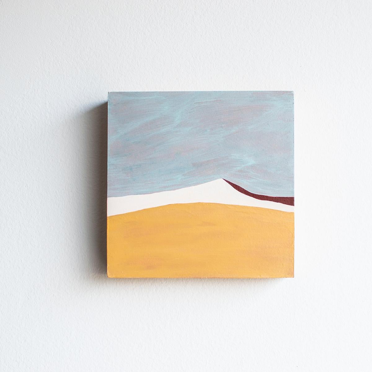 This abstract desert landscape painting by Alina B is made with acrylic paint on board. It features a palette with warm golden yellow and red, contrasted by white and light blue. The light blue sky has a warm undertone, which ties into the