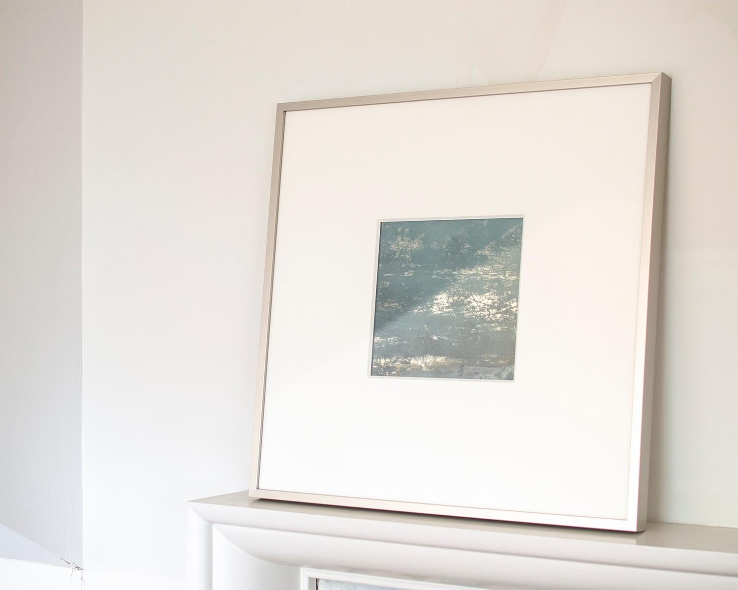 Questo specchio contemporaneo di Alina B. è stato realizzato con tecniche miste su una base a specchio che crea un'estetica riflettente, iridescente e metallica. La composizione astratta blu-argento riflette la luce in modo diverso se osservata da