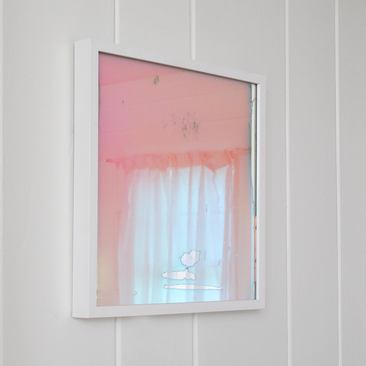 This contemporary piece is made with dichroic film on mirror and is framed in a modern white frame. The artist has applied the film but left small areas without, giving a painterly aesthetic to this mixed-media composition. The area is nearly all