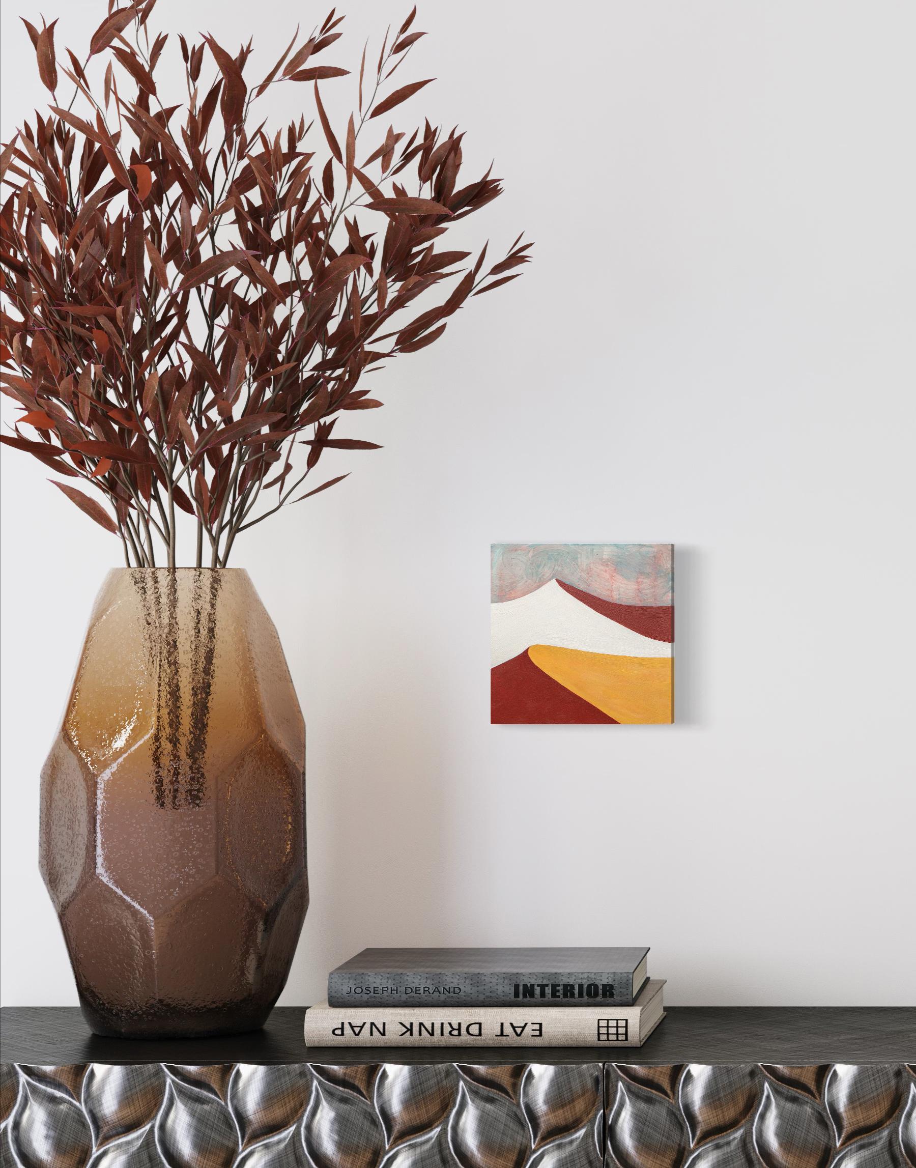 This abstract desert landscape painting by Alina B is made with acrylic paint on board. It features a warm palette with golden yellow and deep red tones, contrasted by white and light teal. The sky is made with light washy layers and a warm