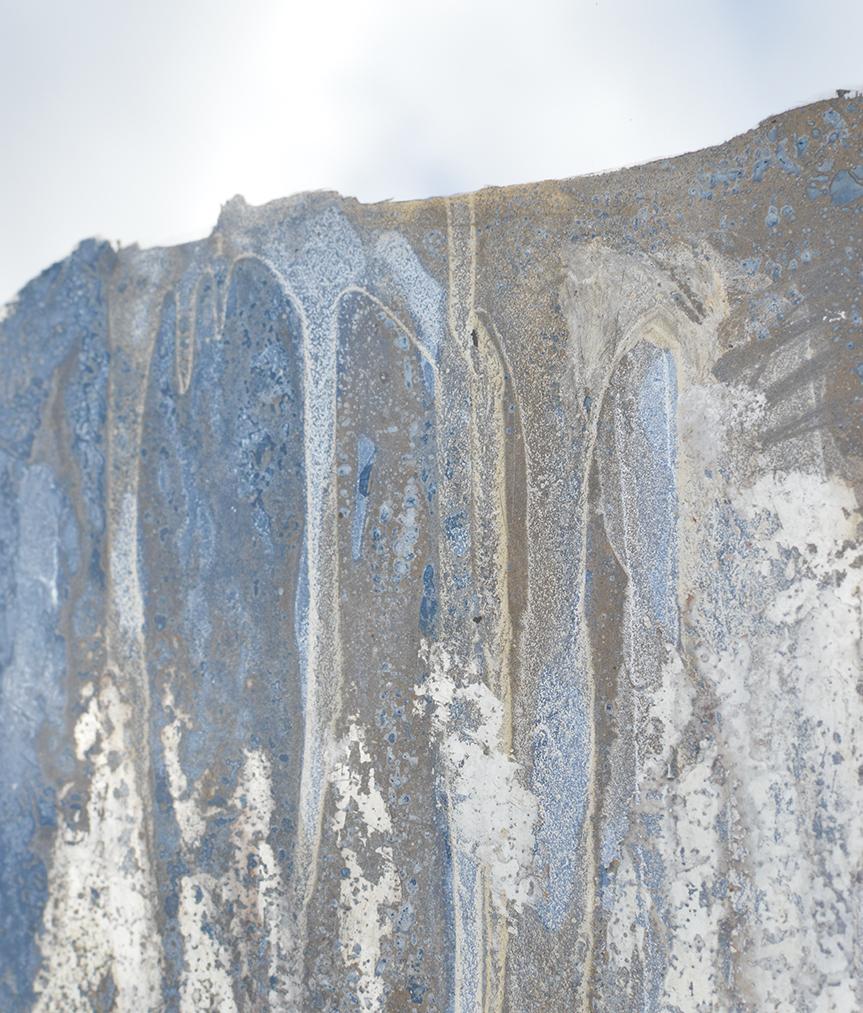 Questo pezzo contemporaneo a tecnica mista è realizzato con tecnica mista su uno specchio circolare. Il colore blu-grigio intenso è stato applicato partendo da sopra e continuando sulla metà inferiore dello specchio, conferendogli un'estetica