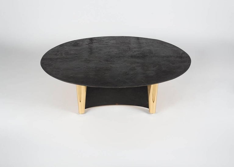 This remarkable piece has a tabletop that rests so lightly upon its two scroll-like bases that it appears to be floating, as well as generous dimensions exceeding the requirements of a coffee table qualities that imbue it with a presence that verges