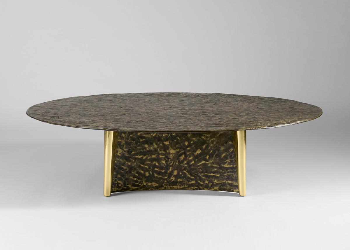 Cette pièce remarquable a un plateau qui repose si légèrement sur ses deux bases en forme de volutes qu'il semble flotter, ainsi que des dimensions généreuses dépassant les qualités d'une table basse, ce qui lui confère une présence qui frise le