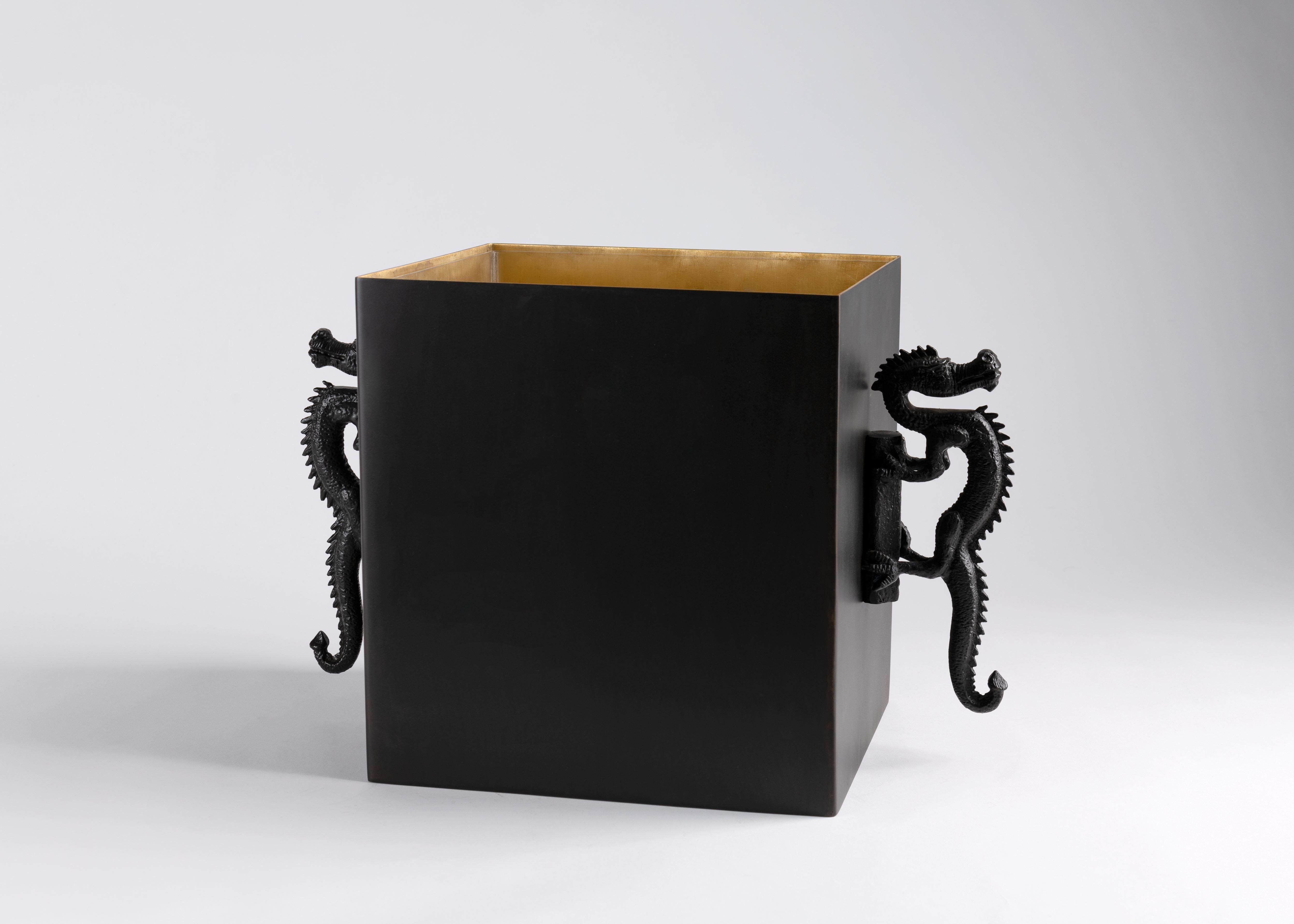 This deceptively simple container, made from sleek, black patinated bronze and lined with soft, contrasting brass, works as either a floor or tabletop vase. The pair of richly textured cast metal dragons that stare defiantly from either side serve