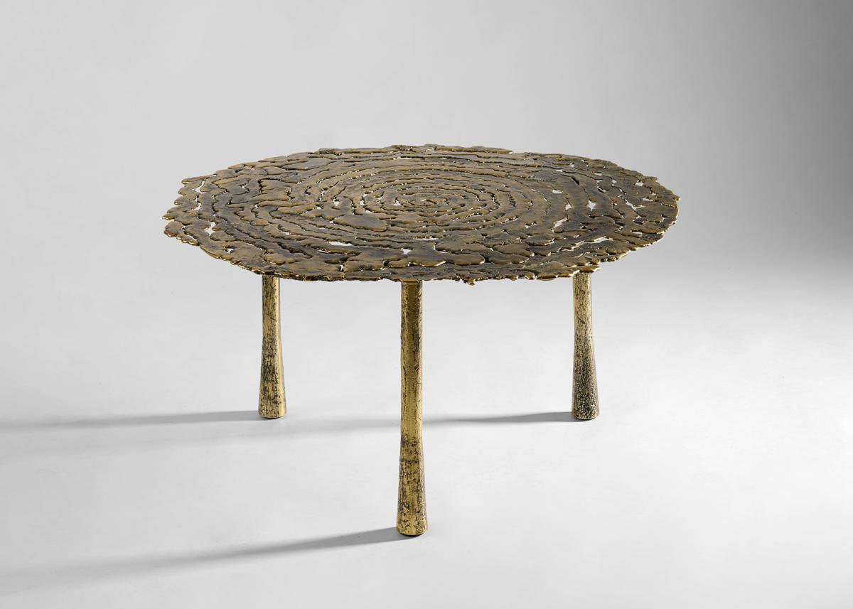 A dynamic piece with a strong sense of motion. Poised on three round legs, the table’s delicate surface is put on full display, drawing the eye to the irregular tones, textures, and hollow spaces that give this table a natural yet refined