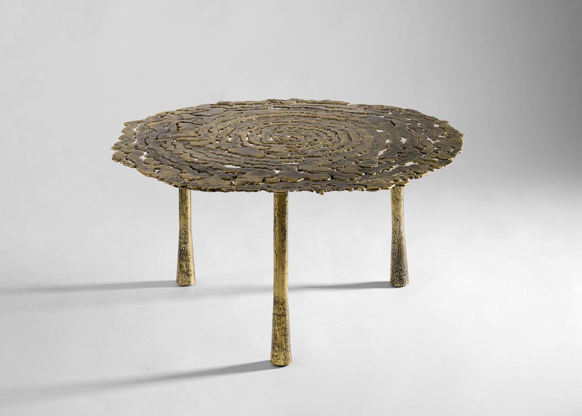 Une pièce dynamique avec une forte impression de mouvement. Posée sur trois pieds ronds, la surface délicate de la table est mise en valeur, attirant le regard sur les tons irréguliers, les textures et les espaces creux qui confèrent à cette table
