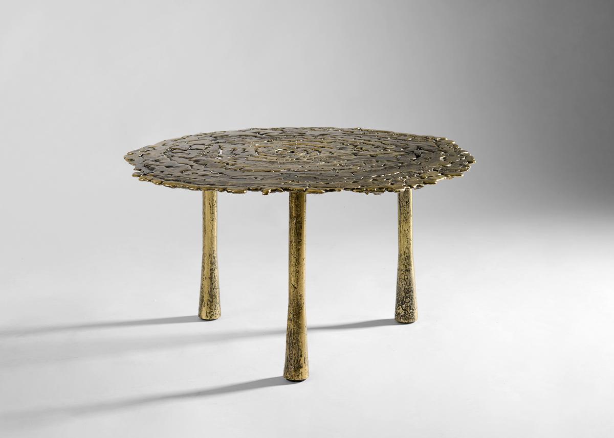 A dynamic piece with a strong sense of motion. Poised on three round legs, the table’s delicate surface is put on full display, drawing the eye to the irregular tones, textures, and hollow spaces that give this table a natural yet refined
